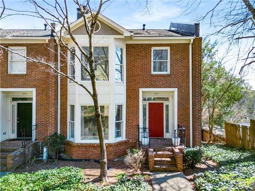 Welcome to this beautifully maintained end-unit townhome with a rare two-car garage in the heart of Morningside. Inside, discover gleaming hardwood floors throughout and a light-filled living room featuring a cozy fireplace and charming bay windows overlooking lush landscaping. The inviting space flows into a separate dining room with new lighting, rich wall color, elegant molding and French doors leading to the back porch.  The bright and refreshed kitchen is a chef's delight, boasting painted cabinets, new lighting, granite countertops, stainless steel appliances and double French doors that flood the space with natural light and open to the back porch. Both the kitchen and dining room seamlessly connect to an oversized deck-ideal for relaxing, grilling or entertaining guests.  A stunning moody half bathroom on the main level features a marble-topped console vanity for a touch of luxury. Upstairs, brand-new hardwood floors lead to two expansive bedrooms. The owner's suite impresses with a bay window, a spacious bedroom and a totally renovated en suite bathroom featuring separate marble-topped vanities and a seamless glass shower with a bench and a built-in niche. The sizable second bedroom with a high ceiling, transom windows and an en suite bathroom.  And don't forget the drive-under two-car garage with a bonus storage room. Morningside Park is a small, sought-after community, a true hidden gem, where homes rarely hit the market. Just moments from Morningside Village's eateries-including Alon's Bakery, shops, such as Savi Provisions and the Morningside's vibrant Saturday Farmers Market. Welcome home...