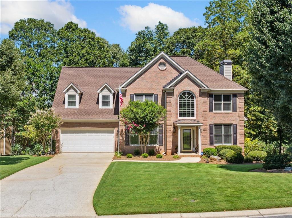Welcome to a beautifully maintained residence nestled in one of Suwanee’s most sought-after neighborhoods, located within South Forsyth County. Stepping inside, you’re greeted by a bright, open floor plan grounded by exquisite hardwood flooring and bathed in natural light. The heart of the home – a beautifully appointed kitchen – flows seamlessly into spacious living and dining areas, perfect for both everyday life and entertaining. The living room features custom built-in shelving and a cozy fireplace, creating a warm and inviting focal point for gatherings or quiet evenings in. The kitchen boasts solid surface countertops, a vent hood, wine cooler, and a full suite of stainless steel appliances. The oven and microwave each feature both standard and convection cooking modes, offering elevated functionality for any home chef. The main level features a sophisticated office or sitting room, highlighted by refined moldings—a thoughtful space for productivity or quiet relaxation. A large laundry room is conveniently located on the main floor, with the washer and dryer staying for added convenience. Upstairs, the generously sized primary suite offers a serene retreat with a spa-style ensuite bath featuring granite countertops, tile flooring, a frameless glass shower, and a soaking tub, along with a spacious walk-in closet. Three additional bedrooms complete the upper level. Downstairs, the finished terrace level provides flexible living space ideal for recreation, guests, or a home gym. The recreation room includes a pool table that stays, offering immediate fun and entertainment. Step outside to your private backyard oasis—a flat, fully fenced yard with beautifully designed landscaping, natural creek beds, and a stone path that invites peaceful strolls. Enjoy year-round outdoor living with a covered patio featuring a Dry Below drainage and ceiling system, keeping the space below the deck dry and functional no matter the weather. The 2-car garage provides ample room for storage, vehicles, and hobbies. Enjoy a vibrant lifestyle with nearby parks, trails, and year-round events. Just minutes away are Town Center Park, George Pierce Park, and the scenic Suwanee Creek Greenway—offering everything from outdoor concerts and playgrounds to miles of trails and green space. All this, plus top-rated schools, local dining, and a strong sense of community. This charming home balances refined interior details with modern conveniences, set against a backdrop of Suwanee’s vibrant lifestyle and natural beauty. Come experience comfort, community, and connection all in one place—welcome home!