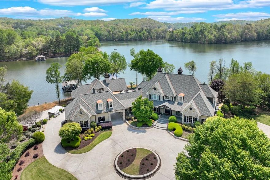 Welcome to an extraordinary waterfront estate on Lake Lanier! Situated within a private, gated setting, this exceptional property spans 4.38  acres and includes three lakefront lots, three private docks, and over 1,600 feet of riprapped shoreline, providing both breathtaking beauty and protection. With 270+ degree lake views from nearly every room, you'll experience the ultimate lakeside lifestyle in this remarkable estate! The custom-built main home has been recently updated and offers three finished levels of luxurious living. From multiple covered porches and patios to a sparkling saltwater pool and hot tub, this estate is ideal for entertaining or simply enjoying peaceful lake living. The chef's kitchen is a true standout, featuring dual islands, a Wolf gas range, Sub-Zero fridge, wine/beverage coolers, and a spacious caterer's pantry. The kitchen seamlessly connects to a sunny breakfast room and a vaulted gathering room with ceiling beams and a gas fireplace. A formal dining room with stone accents and a two-story great room with a grand fireplace add elegance to the space.  A formal study has been transformed into a Bourbon Bar for this owner's enjoyment. The main-level primary suite is a true retreat with expansive lake views, a spa-inspired bath with a steam shower, soaking tub, double vanities, and two custom closets, including one that's over 600 sq ft, plus laundry room. Upstairs offers two guest suites with private bathrooms, as well as a cozy loft space perfect for a home office or reading/study area. The finished terrace level is designed with entertainment in mind. It features a full wet bar, a recreation and billiards room with a two-sided stone fireplace, a media room with custom seating and equipment, and a stunning wine cellar with tasting room. Two additional ensuites provide ample space for family and guests, and there's a large, unfinished storage or workshop area for added convenience. Step outside to the Pool House, an absolute highlight of this property, complete with a vaulted covered patio with a stone fireplace, an outdoor kitchen, and a fully-equipped indoor kitchen with stainless appliances and a large island. It opens to a warm and inviting family room with a fireplace, large pantry, and full bath. Above the Pool House is the Bunk House, currently used as a guest suite with a full bathroom and living area, offering additional versatility. Below the Pool House, there's 840  sq ft of unfinished space that can be used for a workshop, storage, or other personal needs. The property also includes a detached three-car garage with a charming carriage house above, which includes a full kitchen, living room, bedroom, bathroom, and laundry-ideal for guests or additional rental income. An additional one-car garage on the right side of the home provides even more space. This extraordinary estate is a rare find, offering privacy, luxury, and unmatched lake living. Located on the peaceful northeast side of Lake Lanier, just 10 minutes north of downtown Gainesville, The Chattahoochee Country Club,  NEGA Medical and great public and private schools.  Don't miss the opportunity to own one of the most unique and prestigious properties on Lake Lanier!
