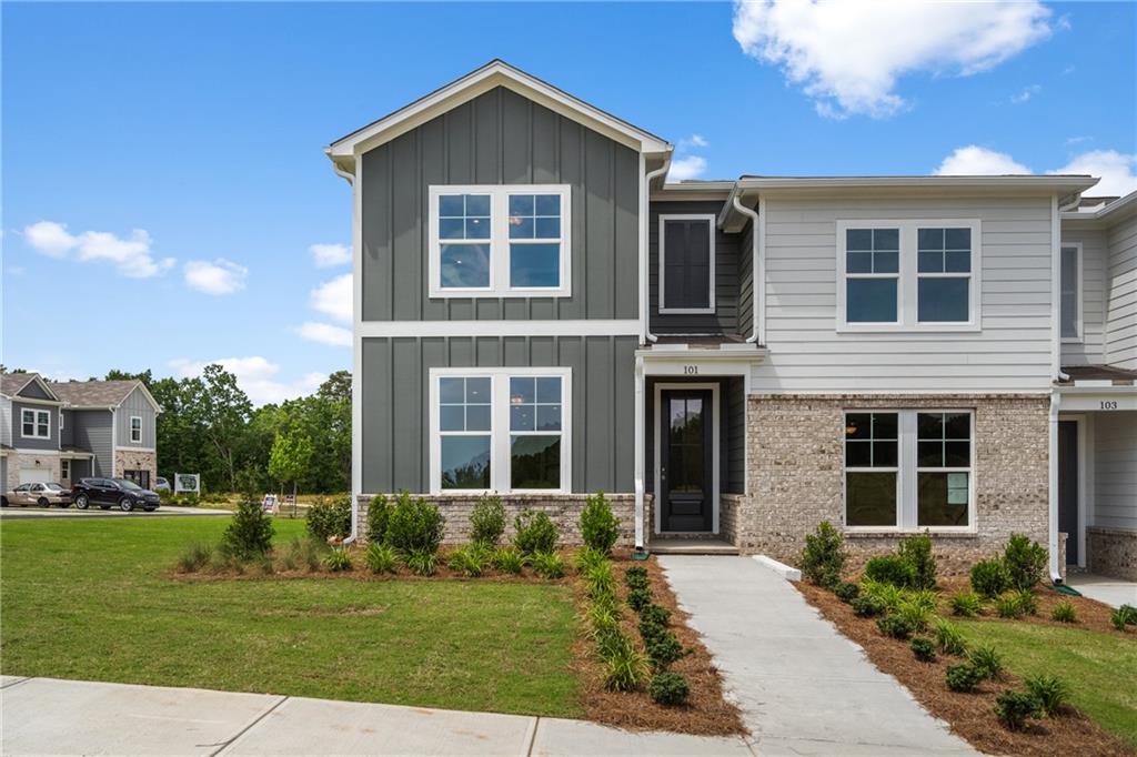 Craftsman inspired home with board and batten siding, a front lawn, and brick siding