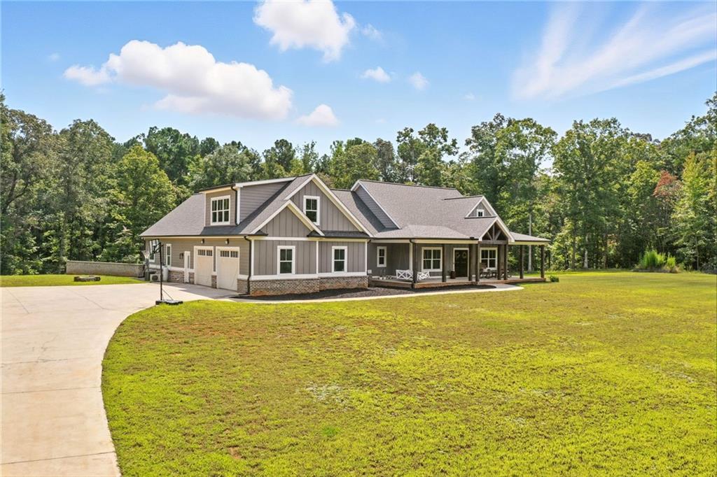 Custom-Built Private Estate on 8.49 Acres in Clayton Community of Canton, GA!
Discover this stunning 2022 custom-built home offering 3,554 sq. ft. of living space, featuring 5 bedrooms, 2.5 bathrooms and a full unfinished basement ready for your personal touch. Tucked away at the end of a long gravel drive that transitions to concrete near the home, this property provides unmatched privacy and tranquility, while still being just minutes from shopping, dining, and I-575.
Set on 8.49 acres, including 3 acres of open yard, there’s endless room for recreation, gardening, or even adding a detached garage or workshop. The oversized two-car garage boasts tall doors for larger vehicles, while the exterior showcases durable fiber cement siding, fascia, and soffit for low-maintenance living.
Step inside to an open floor plan with high-end finishes throughout. The vaulted great room and master suite create a grand, airy feel. The master retreat features a luxurious spa-like bath with a Jacuzzi tub, double-headed tile shower, and a large walk-in closet complete with shoe shelving and a hidden safe room. Additional highlights include hardwood flooring on the main level, tile in bathrooms, plush carpet in bedrooms, a spacious laundry room with sink and dog shower, and a tankless hot water heater.
Enjoy outdoor living at its finest on the vaulted covered back deck with an adjoining open-air section—perfect for entertaining or simply taking in the serene surroundings.
Located in the sought-after Clayton Community of Canton, this property offers the best of both worlds: peaceful seclusion with easy access to Riverstone Parkway, Downtown Canton, and beyond.