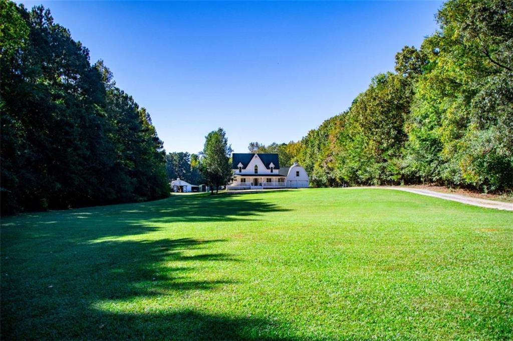 Serene storybook setting less than 5 miles from city conveniences. Equestrian estate located on +-56 acres with beautiful rolling and fenced pastures. Custom 6 Stall barn with temp controlled tack room, lighted outdoor arena, pond and vintage guest home. Main home recently updated inside and out with first-class finishes and southern charm. This magazine-worthy home features a new wrap-around porch, 6 BR, 4.5 BA with 2 addl flex rooms ideal for BR, home theatre, playroom or office. Interior updates include new lighting, paint, flooring, marble/quartz features, gourmet kitchen w/new appliances and countertops, spa-inspired master bath with soaking tub, tiled shower and double vanity. Entire property has a UV and softener right at the well. The master suite overlooks the gunite pool w/state-of-the-art ZeroChlor System. Guest house and in-law/teen suite offer private living and guest quarters. Perfect for your personal estate, while offering year-round entertaining. Easy access to I-20 and ATL airport. This peaceful retreat is a rare find! Seller is offering up to $20k in buyer incentives / concessions.