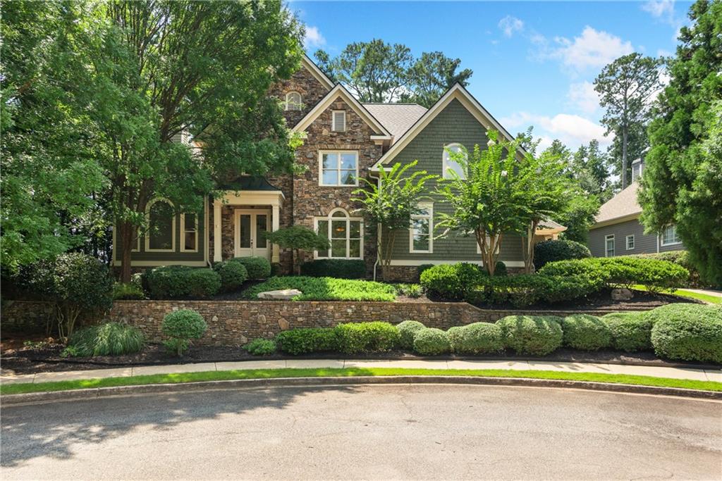 It is rare to find a home that blends timeless beauty with true craftsmanship—yet this residence delivers from the moment you step inside. A sweeping curved staircase, gleaming site-finished hardwoods, coffered ceilings, and a dramatic stacked-stone fireplace set the tone for a home that feels both sophisticated and refreshingly unique. Northeast facing for incredible morning sunlight.
The main-level primary suite is a private retreat, featuring a soaring cathedral ceiling, designer lighting, a cozy fireplace, and a private door leading to the covered porch. The spa-inspired bath offers a double walk-in shower, soaking tub, dual vanities, and a fully customized walk-in closet.
At the heart of the home, the kitchen balances elegance and function with white cabinetry, stone countertops, double ovens, a gas cooktop, pop-up vent, and warming drawer. A built-in hutch showcases your treasures, while the oversized walk-in pantry disguised as cabinetry keeps everything neatly tucked away. Flowing seamlessly into the family room, it is ideal for intimate evenings or lively gatherings.
Additional main-level spaces include a formal dining room, refined living room, and a mudroom with a large laundry, all finished with meticulous trim and high ceilings. Upstairs, generously sized bedrooms and baths provide comfort and privacy for family or guests. The upper level kids entertainment room is ideal for all the toys, a hang out space and ideal study space.
Designed to live beautifully through every stage of life, this home offers abundant space when loved ones are near, yet feels perfectly scaled for everyday living. An expansive rear porch overlooks the private backyard, while the daylight, walk-out basement awaits your vision for future expansion.
Three car, kitchen level garage with one bay heated and cooled!
Nestled at the end of a quiet cul-de-sac in an enclave of custom homes, this residence offers the prestige of a Roswell address paired with the advantage of Cobb County taxes, all within the sought-after Lassiter High School district. New roof installed in April All new paint and carpet and just-refinished wood floors make this home an easy decision. Don't miss your opportunity to see this beautiful home today.
