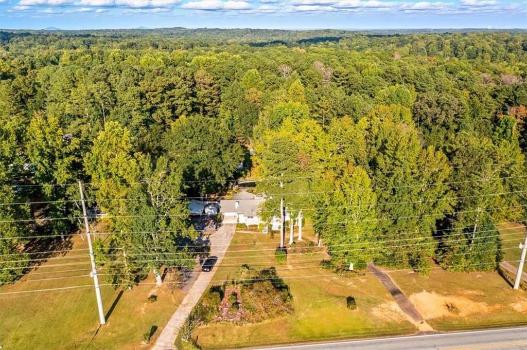 Welcome home, this private retreat nestled on nearly 2 acres of level, usable land. This charming 3-bedroom, 2-bath ranch-style home offers the perfect blend of comfort, space, and functionality. Step inside to a light-filled family room featuring a stunning factory-built rock fireplace, ideal for cozy evenings. The kitchen is equipped with white cabinetry, a breakfast bar, an eat-in area, and a separate formal dining room-perfect for everyday living and entertaining guests. Enjoy year-round relaxation in the enclosed sunroom, or unwind outdoors on the large back deck overlooking a private, fenced backyard complete with an in-ground pool and hot tub. This property is designed for both peaceful mornings and lively gatherings. Additional highlights include ample parking, a covered front porch, and a detached storage building. Recent upgrades include a newer HVAC system and water heater (approximately 2 years old), energy-efficient windows, gutter guards, and extensive kitchen storage. Located in a peaceful setting with no HOA, this home delivers a turnkey lifestyle with room to grow.