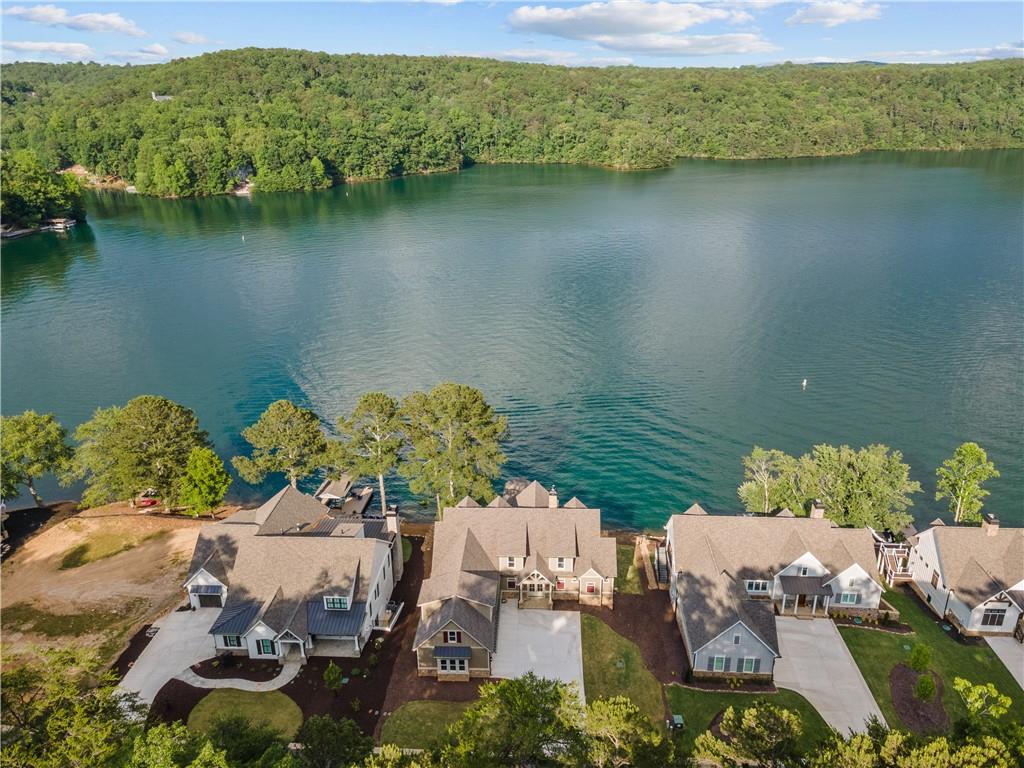 Priced below appraised value! Brand New Custom Build - One of a kind lake house with boat dock! Only a few steps to the pristine Lake Arrowhead water with stunning water views (96' of water frontage) throughout most of the house! This spectacular 5528 square foot house offers 6 bedrooms (3 amazing Master/En suite Bedrooms— 2 on main and one on terrace level) and 5 full baths and 1 half bath. The 3 other (secondary) bedrooms are all large — offering plenty of room for everyone.  The open floor plan on both the main floor and terrace level provides perfect entertaining spots to enjoy lake life with family and friends! The covered porches off the family room and both Master Bedrooms on the main level offer amazing mountain and lake views. The covered flagstone patio and steps are right off the terrace level leading to the lake. This home offers a 3 car garage and has 3 stone fireplaces (main, covered porch, and terrace level).  The attention to detail throughout the house is spectacular with upgraded finishes, fixtures, exposed beams, and shiplap.  The finishes in the bathroom are all unique and creative — perfect for the lake.  Some additional upgrades include MoistureShield Vision Decking (decks and dock), whole house CAT-5 Cable, Gas Wolf Range, 42' Sub-zero Fridge, Bosch Dishwasher, wired for future whole house generator, craftsman door and window trim, rough sawn mantle, irrigation system, 2 Rinnai tankless water heaters, shaft for future elevator, wired for electric car, custom pet spa/bath, and much more!  Tons of closet space throughout home.  Enjoy Mountain and lake views in this beautiful, gated, golf and lake community close to shopping and restaurants!