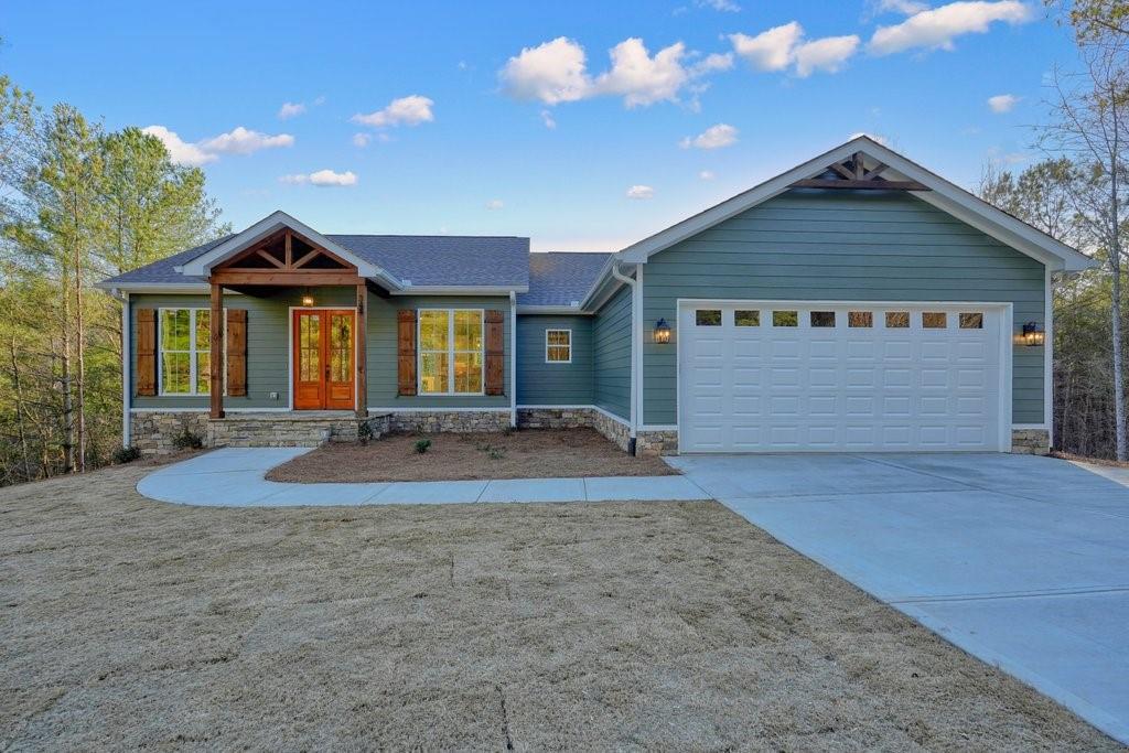 Nestled in a peaceful setting with no HOA in the desirable Hunters Ridge subdivision, this stunning 3-bedroom, 2.5-bathroom home sits on over 1 acre of beautifully landscaped land with lush Bermuda grass. Offering a perfect blend of modern upgrades and timeless charm, the spacious open-concept design features a large kitchen with white cabinetry, quartz countertops, a brick backsplash, and a walk-in pantry, seamlessly flowing into the great room—ideal for entertaining or family gatherings. The oversized master bathroom is a true retreat, complete with a rainfall shower, soaking tub, and beautifully tiled shower. Enjoy outdoor living on the two back decks, one on the main level and one on the basement level, offering serene views of the private yard. The full basement, already stubbed for additional bathrooms, provides endless potential for customization. This home combines modern convenience with tranquility, making it the perfect place to call home.