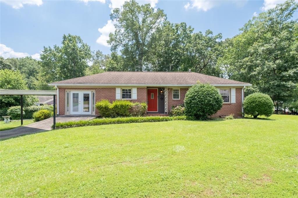 Wonderful 4 sides brick ranch on a park like corner lot in desirable Smyrna! This classic ranch features 3 Bedrooms 2 Full baths plus a large Den with warm masonry fireplace added onto home by current owner. The Chefs' kitchen features stained wood cabinets, vinyl flooring, good counter space and granite tops. Formal Dining Room off kitchen. Primary bedroom also expanded to include a second closet and larger full bathroom. The second Den or Bonus Room is located off the Kitchen and offers extra square footage. It was the original carport. Generous Laundry room is located off the second Den. French Doors off larger den leads to a very peaceful screened porch. Yard is a gardeners delight with a large level fenced sodded yard and an outbuilding that remains for additional storage. Other Owner improvements include covered parking, newer windows and a brand-new June 2025 Heating and Air system using R-32 along with a new CO 2 detector. Under carpet in much of the home are hardwood floors. Home is vacant but easy appt with agent.