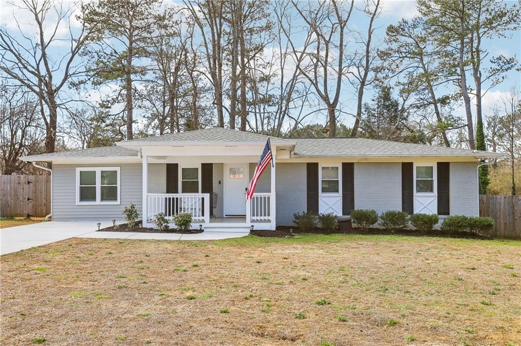 **Wood floors**Bright open spaces**Updated kitchen**Updated bathrooms**Large fenced backyard with deck and dire pit**Charming Ranch with Modern Finishes and Endless Flexibility! This beautifully updated ranch home sits on a sweeping front yard and boasts a stunning exterior with a spacious front porch—perfect for rocking chairs and enjoying cool Georgia evenings. Step inside to discover hardwood floors throughout most of the home and a bright, open-concept layout filled with natural light. The inviting living room features recessed lighting and modern paint tones, while the updated kitchen showcases a large island, granite countertops, stainless steel appliances, tile backsplash, and abundant cabinet and counter space—ideal for both everyday living and entertaining. Retreat to the oversized primary suite, complete with a versatile attached room—perfect for a home office, nursery, or sitting area—with quick exterior access for morning coffee or letting pets out. The en-suite bath includes granite counters and a walk-in tiled shower. Two additional spacious bedrooms share a full hall bath featuring granite counters and a fully tiled tub/shower combo. On the opposite side of the home, you’ll find a generously sized fourth bedroom with a private half bath—ideal as a guest suite, MIL suite, home office, gym, or media room—the options are endless! Step outside to a large, fully fenced backyard featuring a deck, fire pit, and lush green space surrounded by mature trees for added privacy. Additional upgrades include premium tinted energy-saving windows. Located just minutes from I-75, The Battery, shopping, and dining—this home combines style, space, and location. Don’t miss your opportunity to make it yours!
