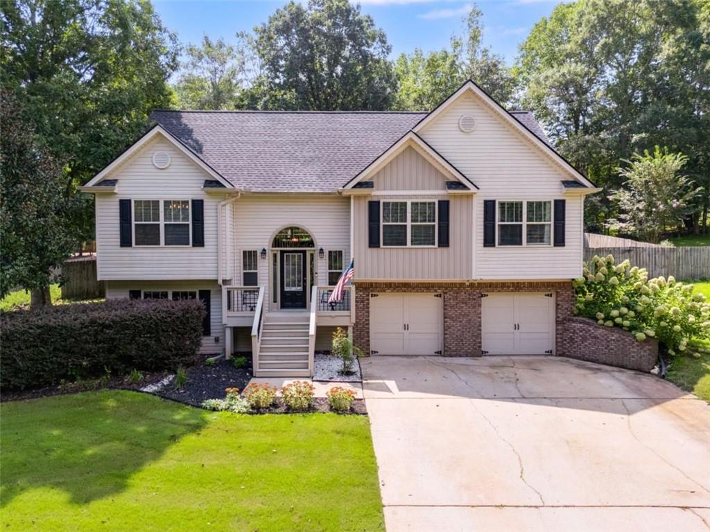 This spacious home in the South Paulding school district offers a great combination of comfort and flexibility. The exterior features a wooden privacy fence, a large entertainment deck, and an additional outbuilding for storage or hobbies. The yard is beautifully landscaped with lush Tiftway Bermuda grass, established flower and shrub beds, and irrigation to keep everything thriving.
Inside, a dramatic curved staircase sets the tone for the main level, which features fresh interior paint, updated on-trend light fixtures, and laminate hardwood floors in the living room, dining area, and bedrooms. The living room is anchored by a cozy fireplace and built-in bookcase along the interior wall, adding both charm and functionality.
The lower level offers a generously sized bedroom, a full bathroom, and an expansive flex space — with private access from both the front entry and the garage — creating opportunities for guests, separate living arrangements, or a home office. The garage also includes an additional storage room for added convenience.
Enjoy nearby dining in Downtown Temple, abundant local parks, shopping in Villa Rica and Dallas, plus easy access to I-20 for commuting.