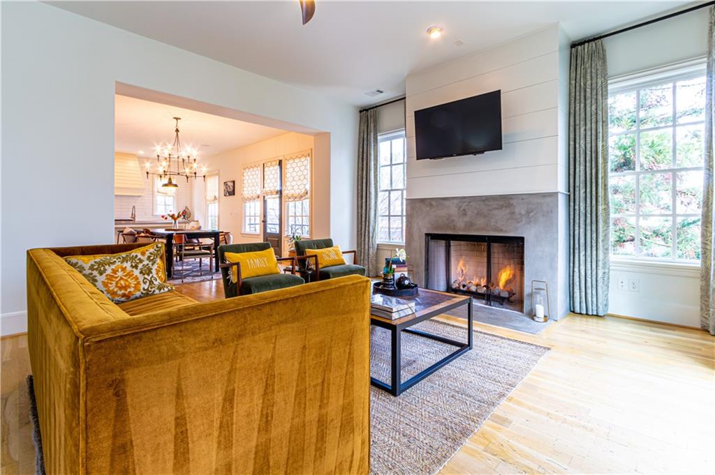 Living room with a high end fireplace, light wood-style flooring, and a chandelier