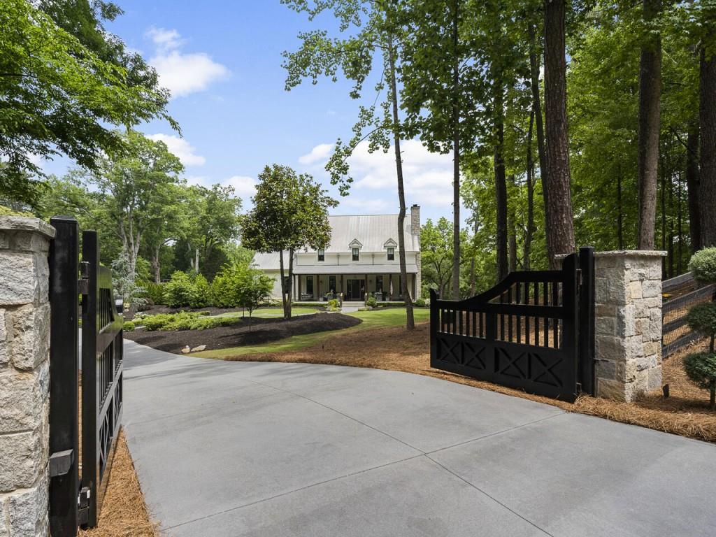 Gated Custom Modern farmhouse New Construction w/ all the current bells & whistles built by Steve Powell Homes. Located minutes from downtown Alpharetta & Avalon Shopping Experience. Privacy & Natural landscape is all yours. Home is overlooking 100 year old whispering oak trees and sits beautifully on fully usable 2.45 +/-acres. Large front porch with cedar beams with tongue & groove ceiling, two porch swings & a natural landscape full of birds singing & squirrels joyfully playing. Relax on the wonderfully designed lanai w/ amazing bi-folding glass doors that lead to ahuge Penn Blue stone heated pool w/ heated spa & accent waterfall. Full pool Bath & Fire Pit make entertaining outdoors effortless. 12 ft ceilings on Main Level, Open Floor plan invites you into Chefs kitchen w/ rustic beam ceiling, oversized Quartzite island for true entertaining, Thermador appliance package, custom built vent hood. Pennsylvania Barn wood Hardwood flooring stained & treated w/ natural Rubio Wax throughout, beautiful windows on main floor bringing in loads of natural light. Exquisite design selections throughout home include tile, light fixtures & hardware. Owners suite on Main Level w/ spa-like bath w/ heated floors & large his & hers closet w/ island custom built-ins, Wonderful laundry/mud room w/ 2 washers & 2 dryers, farm sink & tons of storage. Large secondary bedrms upstairs w/ private baths & great walk-in closets w/ custom built-ins, Study nook. Terrace Level features bedrm w/ full bath, Workout room, Home theater, boat/car garage/workshop with great storage space w/ built-ins. Beautiful winding driveway w/ additional parking pads for entertaining. Full house gas generator, Control 4 Home automation w/ indoor/outdoor lighting, audio & security system.