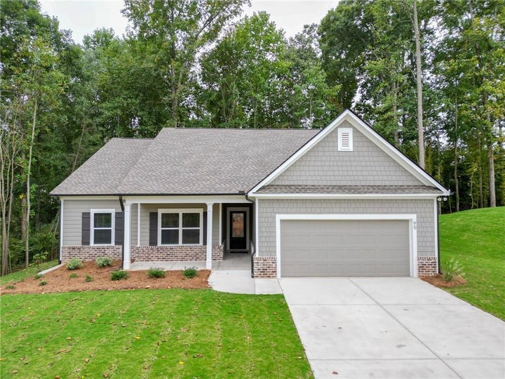 New construction home featuring a two-car garage, covered porch framing, and a shingle roof