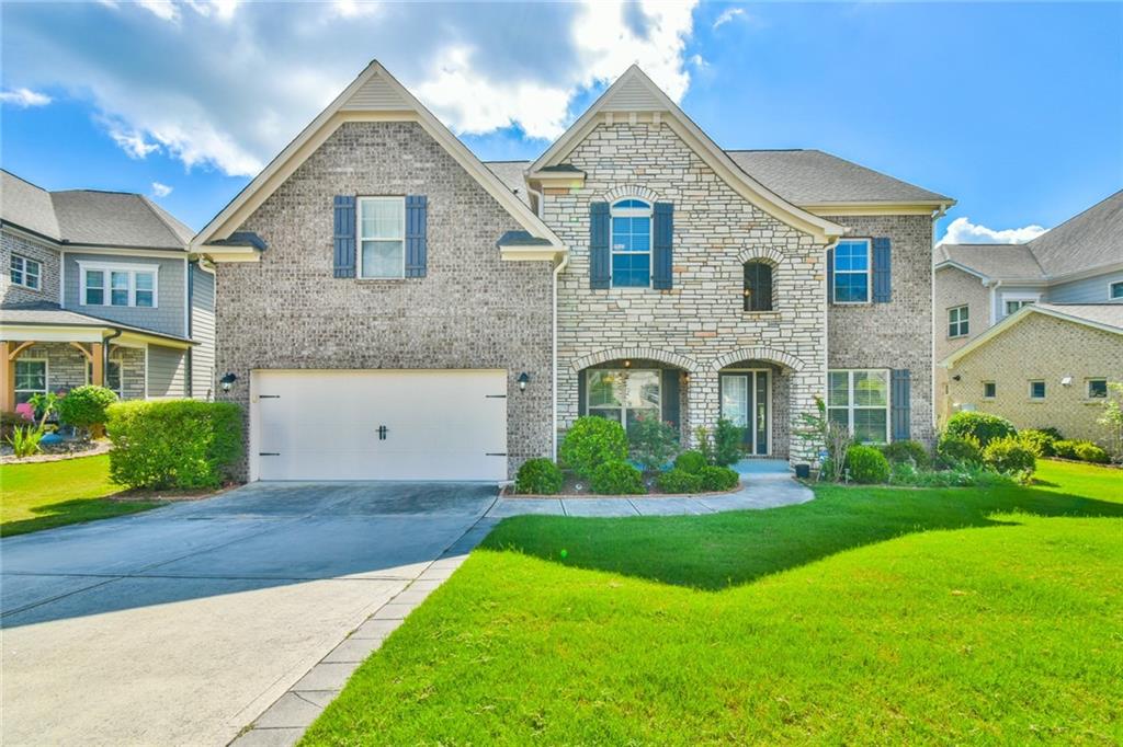 Located in the highly desirable Ashford Crossing community, Welcome to a 5 bedroom and 4 full bathroom single family house with a bedroom and full bathroom on the main level. Thoughtfully maintained over the years, on entry, you're welcomed by gorgeous hardwood flooring and a grand, airy foyer filled with natural light. The classic layout includes a formal dining space to the left and a private study with French doors on the right—perfect for working from home. Moving forward, the kitchen seamlessly connects to the living area, creating an ideal gathering space. Nearby, a conveniently placed guest bath and a built-in drop zone provide an efficient space to keep daily essentials organized. Upstairs, a spacious loft serves as a natural divider between the primary suite and the secondary bedrooms. Two of the bedrooms share a Jack-and-Jill bathroom, each with a walk-in closet and individual vanity, while the third bedroom has its own nearby full bath. The laundry area is also on this level for added convenience. The expansive primary retreat easily accommodates large furnishings, offering a peaceful view of the front yard. Its en-suite features separate vanities, a soaking tub, a walk-in shower, and a private water close. A fifth bedroom and full bath provide ideal guest accommodations or multi-generational living options. This home is just a short walk from the community's swimming pool, tennis courts, and playground. With and meticulous upkeep, this stunning Sugar Hill home is move-in ready—schedule your showing today!