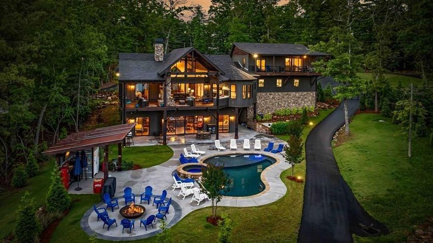 Indulge in the epitome of luxury living at this extraordinary lakefront sanctuary! A grand entrance welcomes you with a majestic floor-to-ceiling stone wood-burning fireplace & intricate architectural & rustic details that frame panoramic views of Lake Blue Ridge & the majestic mountain landscape. Enter the heart of the home, where a gourmet kitchen featuring Viking appliances, an enhanced butler's pantry, & unmatched attention to detail await. With six luxurious ensuite bedrooms spread across both levels of the main residence, each guest is pampered with unmatched comfort. The primary suite is a haven of extravagance, boasting a zero-entry tile shower, heated flooring, a lavish jetted tub, and the ultimate touch of refinement - a bidet for unparalleled luxury. Enjoy entertainment without limits in the lower level, where a full wet bar seamlessly transitions to an outdoor kitchen, a serene pool, a rejuvenating hot tub, a delightful pool house with a half bath, and a captivating fire pit area. For additional accommodations, the three-car garage hosts a sophisticated 2-bedroom, 2-bathroom apartment above, perfect for guests or staff quarters. Live the pinnacle of luxury with premium amenities such as a whole house generator, a private fenced backyard catering to both privacy and pet-friendly needs, and a newly installed double-decker Wahoo boat dock complete with a 2022 Barletta 24' pontoon boat. Additionally, a full RV hook-up including 50 amps, water, and sewer connections adds further convenience and versatility to this remarkable property. Offered fully furnished, this residence presents a compelling opportunity as a successful short-term rental, blending unparalleled comfort with exceptional investment prospects. With a host of exceptional extras included by the homeowner, this home promises a lifestyle of unrivaled opulence and sophistication that surpasses all expectations.