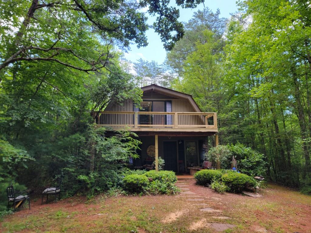 This is your opportunity to Escape to Your Mountain Sanctuary! Nestled in a serene natural setting, this enchanting cabin offers the perfect blend of rustic charm and modern comfort. Fantastic new front porch and deck! With three bedrooms, one and a half baths, and unique touches throughout, this haven is ideal for those seeking a peaceful retreat or a savvy investment opportunity. Previously a successful Airbnb, this property boasts excellent potential for rental income, making it an attractive option for those looking to diversify their portfolio. Unwind on the expansive deck, surrounded by nature's tranquility, or gather 'round the cozy fireplace for quality time with loved ones. The functional kitchen ensures everyday convenience, while the cabin's character-filled details will make you feel right at home. Whether you're seeking a primary residence, a vacation getaway, or a shrewd investment, this mountain retreat offers the ultimate blend of comfort, practicality, and natural beauty. Don't miss your chance to own this rustic gem! Sold AS IS.