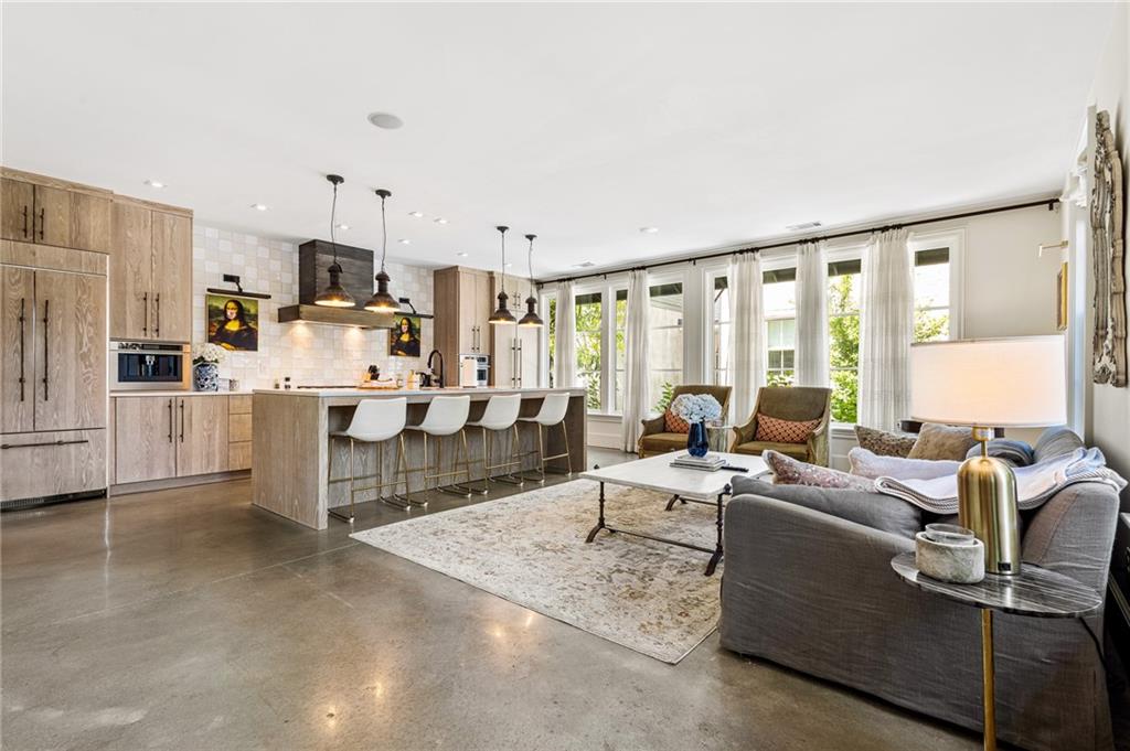 Living room featuring plenty of natural light, finished concrete flooring, and recessed lighting