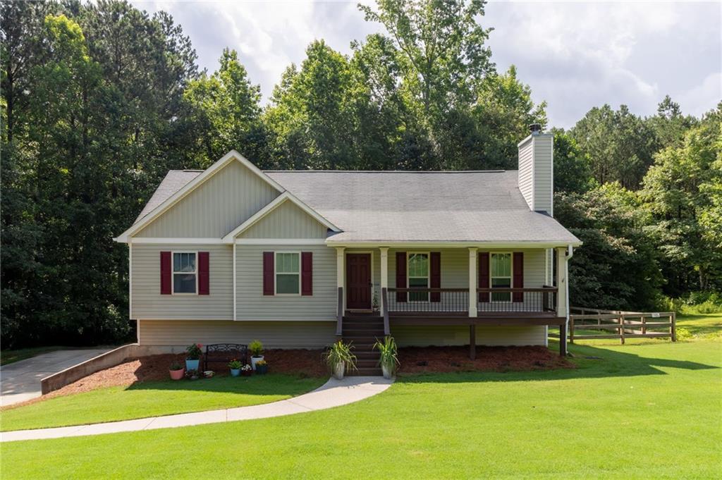Welcome to your dream retreat. This adorable home features an open concept floor plan with hardwood floors throughout the main living area, perfect for everyday living and entertaining. The kitchen, dining, and living areas flow seamlessly together, creating a warm and inviting space. The cozy primary suite offers a peaceful escape with a spacious en suite bathroom, complete with a relaxing soaker tub and plenty of room to unwind. Downstairs you’ll find an oversized bedroom with space for a seating area, along with a professionally soundproofed room that works perfectly as a home office, music studio, or man cave. There is also plenty of room for a home gym. You can work or play without worrying about waking the kids. The oversized garage comfortably fits two vehicles and still leaves room to store gear, set up a workshop, or tackle weekend projects. Step outside and enjoy a large deck that’s ideal for gatherings, grilling, or relaxing. The fenced-in backyard is great for pets and plenty of room for a playset. The property backs up to peaceful woods, giving you both beauty and privacy. This home sits on a generous lot in a quiet setting just minutes from town. Come see it for yourself and fall in love.