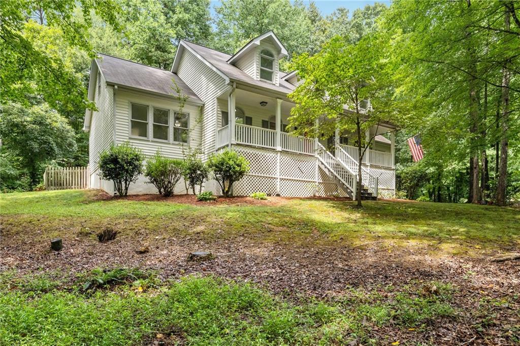 Check out this amazing 4 bedroom, 2.5 bath that sits in convenient Marietta, but has a setting that feels like it's miles from anywhere. This great home is set far off the end of a cul-de-sac and surrounded by mature tress and a babbling creek. Sitting on your covered front porch or screened back porch, you can enjoy the privacy of this large secluded lot without looking into your neighbors yard. As you enter the home, you will find real traditional hardwoods floors, two story ceilings, a separate dining room and large eat-in kitchen with bar topped island looking into the living room. It features a large master-on-main with a huge owner's bath and large walk-in closet. Head upstairs to find 3 additional bedrooms and a guest bath. If storage is what you need, there is a huge amount of space in the basement, already plumbed for a bathroom for more expansion. With new interior paint, new carpet and bathroom flooring, updated hardware and  new lighting fixtures, this home is ready and waiting for you.