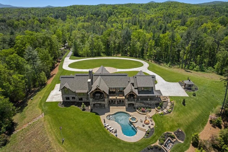 Introducing: Black Bear Lodge. Watch video tour here -> https://youtu.be/WTRtKHiKkJU This Mountain Estate sits on 14+ acres overlooking pristine lawns, rolling hills, sprawling trails, natural forest beauty, and 10 miles of mountain views. Designed by architect Steve Crane and constructed by R.E. Black Custom Homes, this 8,500 square foot lodge was completed in 2020 and took over four years to complete. Upon arrival, the multiple front porches featuring covered seating areas are perfect for outdoor living. The exterior of the home is finished with beautiful artisan hardiplank woodwork, stone, and cedar shake. Entering the grand foyer, 27-foot ceilings tower over the main living room, featuring a seven by five-foot Crab Orchard stone fireplace. This home boasts five masonry fireplaces designed by local stone artisans. The lodge features plaster walls throughout with red and white oak flooring in 6, 8, and 10-inch variations. The towering cathedral ceilings feature heavy mortise & tenon rough-sawn timber beams that extend into the kitchen. The Dining room and kitchen flow perfectly into the living room for effortless entertaining. Completed by  Kingdom Woodworks and Francois & Co, the kitchen features; a 10 burner, 60 inch Blue Star range, Dueling 42-inch Wolf refrigerator and freezer, two Bosch dishwashers, a Wolf microwave, and a scullery featuring a 42-inch Miele refrigerator and freezer with wet bar and ice maker. Off the kitchen and living room, sliding glass doors will welcome you to a two-story stone balcony. Complete with outdoor living featuring a fireplace, ample room for dining, and a covered kitchen featuring; a 6-burner Wolf stove top, Kitchen Aide warming and cooling drawers, Sharp microwave, beverage cooler, sink, ice maker, leathered Black Pearl countertops, a 60-inch Santa Maria grill and Bromic heating systems; this terrace has it all. As you head down the Texas Flagstone stairs, you are greeted by the seven-foot fire pit, hot tub, and heated pebble tech saltwater pool, and views of the lawns and mountains.  Off the kitchen there is a half bath, laundry room and three-car garage with epoxy flooring. The upstairs features a bedroom with a study and multi-use bunk and playroom. The primary bedroom features a fireplace, vaulted ceilings, and views of the pool and mountains. The spa inspired bathroom is designed with an oversized Karya Royal marble shower, floating bathtub, duel vanities, Kholer toilets and a Biobidet. Off the bathroom are substantial his and her closets and an elevator to the terrace level. The grand timber frame staircase to the terrace level will greet you with reclaimed Terracotta Parefeuille flooring imported from France. With rough-sawn distressed beams, the terrace level features a full bar with a built-in TV, Bosch dishwasher, Subzero icemaker, two wine coolers, multiple beverage drawers, and a microwave.  There are two separate living areas with another masonry fireplace, pool table, three full guest suites, full bathroom for pool guest, and an office.  This estate  also features a full-home generator, Hellenbrand water filtration system, moonlighting and canopy  landscape lighting across the grounds, foam insulation throughout, smart home Lutron lighting systems, two tank less water heaters, Kolbe casement windows throughout, drapery remote control, state of the art security with hard wired cameras, and more.