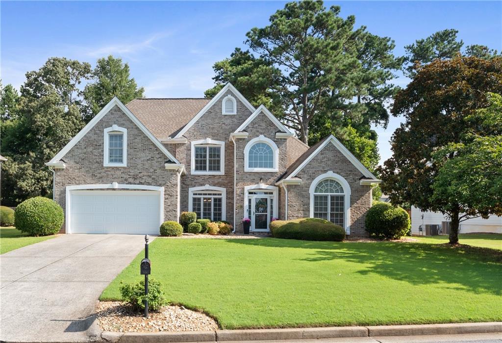 Welcome to this thoughtfully updated 5BR/2.5BA brick-front home in Alpharetta, offering comfort, space, and modern style throughout. The main level features a convenient primary suite, interior/exterior paint (2022), hardwood floors—no carpet. Enjoy the bright 2-story great room, vaulted-ceiling office or music room, updated lighting and modern ceiling fan. The kitchen features white cabinets, quartz countertops, an island, and newer appliances (2022). Bathrooms were refreshed in 2022 with tiled showers and double vanities with quartz top. Custom closet systems in the pantry, hallway, and most bedrooms. Smart features include an Alexa thermostat, Ring doorbell, and a new garage door with opener (2025), plus epoxy-coated garage floors. Main-level laundry with window and utility sink. Fenced backyard with patio, and an extended driveway with plenty of guest parking. Close to top-rated schools, shopping, and parks.