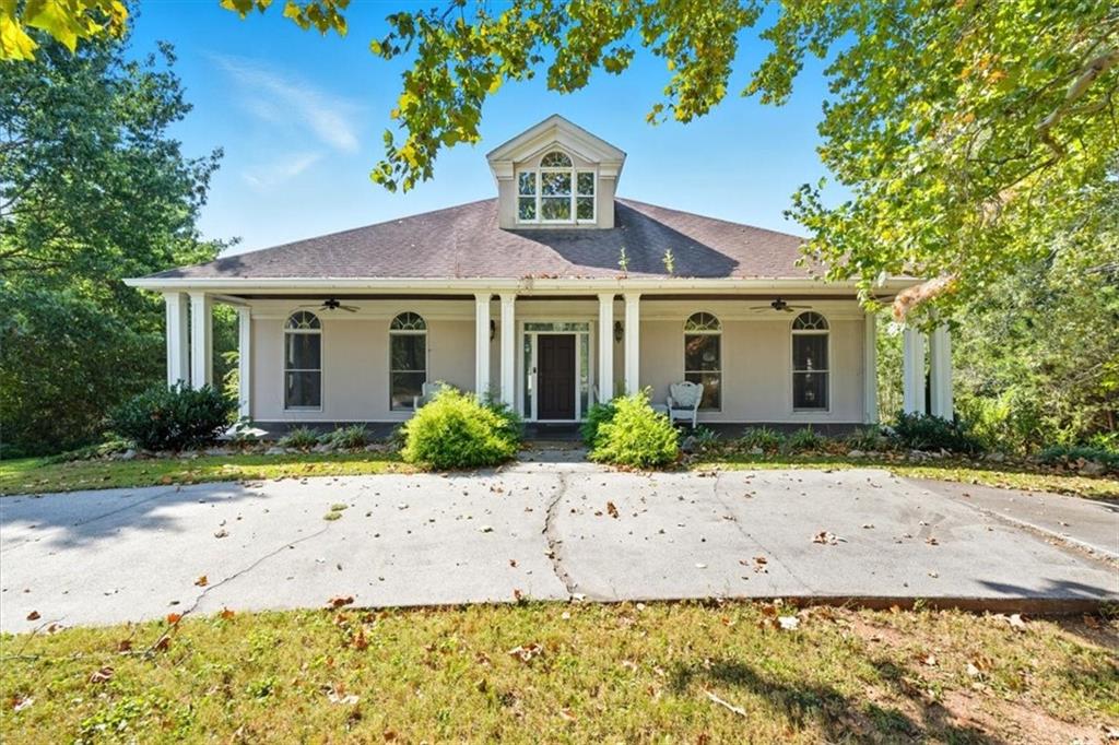 This home blends timeless charm with modern upgrades. A covered front porch with stone tile, tongue-and-groove ceiling, and white columns welcomes you in. Inside, enjoy polished hardwood floors, vaulted ceilings, crown molding, and recessed lighting.
The kitchen features navy cabinetry with silver hardware, new sink (2023), built-in oven, microwave over gas stovetop, and a 2022 dishwasher. A remodeled bathroom (2023) offers a glass-enclosed shower, freestanding tub, and walk-in closet with shelving.
Additional highlights include a wood staircase, laundry room with cabinetry, fireplace with mantel wall, updated CATV Ethernet wiring, Vivint security system, and Ecobee thermostat upgrade (2024).
Outside, a detached double garage, curved concrete driveway, and views of the community lake complete this beautifully updated property.
