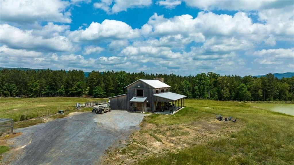 Absolutely Amazing is a huge understatement. This is the most beautiful piece of property I have ever had the opportunity to work with. This 354 acre working cattle farm has 360 degree mountain and valley views. The 3 bedroom 2 bath custom, top of the line, home sits in the middle of the property overlooking a stocked 3+ acre private lake. There are 10+ miles of fencing in the 270+/- acres of pasture. 3 wells on the located on the property that service 7 concrete on demand water pads located in the pastures for easy watering of your livestock. Ready to work your animals. All the pastures are paddocked with an easy transition into the covered and enclosed 8,800 sf livestock working barn. The livestock barn has built in gate systems, head catches, and weight scales. All will remain. There are also 2 large hay barns that can hold over 1,000 round bails of hay. The farm also features a chicken coup, quail raising pen, equipment barn, and multiple other water sources. This farm is truly spectacular and ready for anything. Don't need that much land? There are 2.5+/- miles of road frontage and county water available. This would give the buyer the option to split this farm up and sell off smaller tracts to recoup some of your investment.