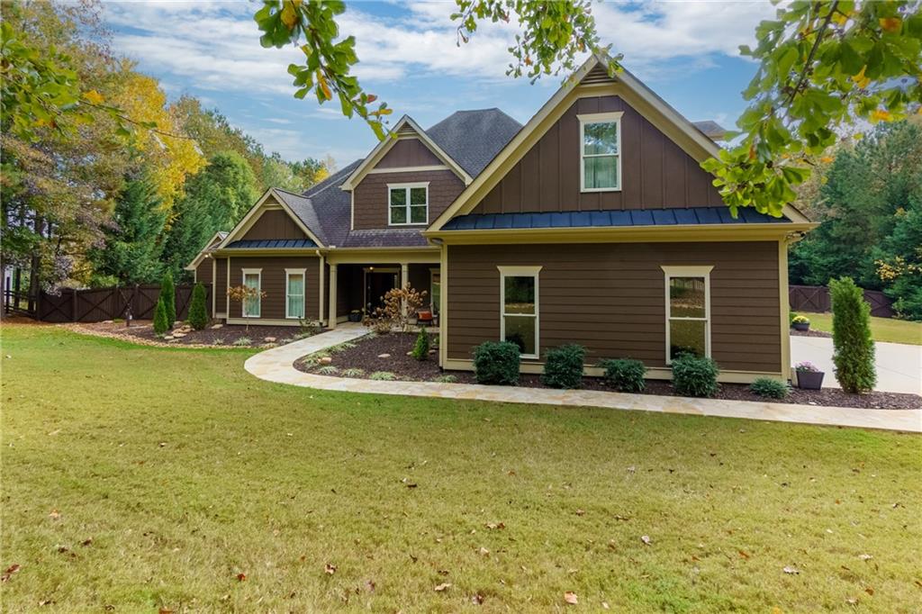 Tucked away at the end of a serene cul-de-sac on over an acre, this expanded Craftsman home offers timeless charm with a private setting. Designed for both style and function, the professionally curated interior features distinctive details and luxurious finishes, highlighted by Ralph Lauren metallic paint throughout. The main level boasts an open floor plan ideal for entertaining, anchored by a beam-framed dining area that exudes character. Adjacent, French doors lead to a sunroom ideal as a home office or gym, offering peaceful views. This floor also features two spacious bedrooms, including a luxurious primary suite with an ensuite bathroom, and two additional full bathrooms plus a convenient powder room. The open-concept kitchen is equipped with premium Jenn-Air appliances, full-wall cabinetry, and a walk-in pantry featuring four electrical outlets and a cleverly concealed space for small appliances. A state-of-the-art water purification system ensures pristine water quality. Upstairs, two additional bedrooms, each with its own private bathroom, provide an inviting retreat for guests. Additional highlights include a storm cellar or underground bunker, adding an extra layer of security and peace of mind. Outdoor living spaces abound, with a covered walk-out patio, a separate paved grilling area, and a newly constructed workshop fully wired for cable and internet. A spacious 3-car garage offers ample parking and storage, while a cutting-edge 4K security camera system is integrated directly into the home's TV wiring for added convenience. Offered fully furnished and move-in ready, this home is a true gem that's ready to be enjoyed.