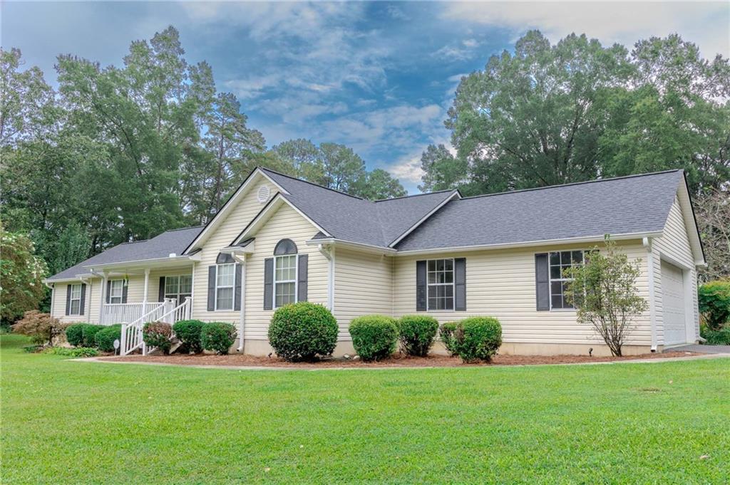 Welcome to this well-maintained 3 bedroom, 2 full bath home perfectly situated on nearly 5 areas of peaceful land. Inside you'll find an inviting layout featuring a spacious family room with hardwood floors, vaulted ceiling, and gas fireplace. The oversized primary suite has two spacious walk-in closets and the ensuite bath has a garden tub and separate shower. The dining room leads to a cozy sunroom perfect for relaxing. There is plenty of storage in the dedicated laundry room. The beautifully landscaped yard offers the perfect blend of open space and privacy complete with a storage building with power for all your workshop or hobby needs. A 2-car garage provides convenience and additional storage. Whether you're looking for room to spread out, space for outdoor activities, or simply a move-in ready home in a serene setting, this property checks all the boxes.