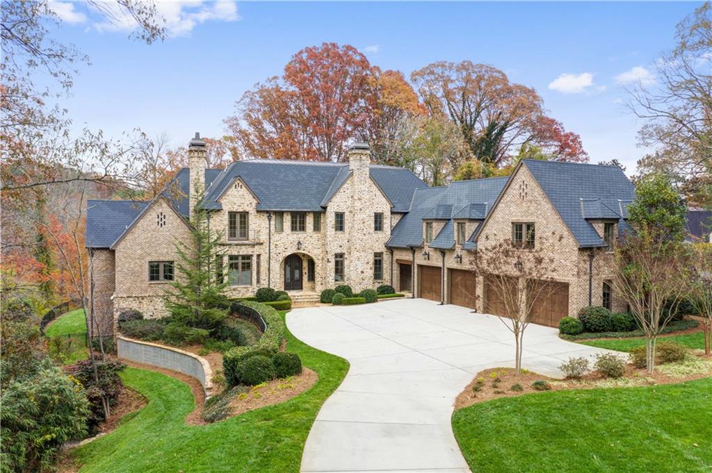 Exclusive estate surrounded by over 2 acres of natural grandeur adjacent to an 8-acre lake. A country home w modern European flair on a grand scale. Massive living spaces, 12’ ceilings on all levels, architectural accents & walls of windows w sweeping forest views. Excellent floorplan w/Master on main. Top floor childrens’ wing with adjoining “pajama” room & full 2 bed/2 ba apartment with complete kitchen perfect for family or au-pair. Sports fans will love the full basement complete with full mahogany bar & many TVs, wine cellar w/tasting room.