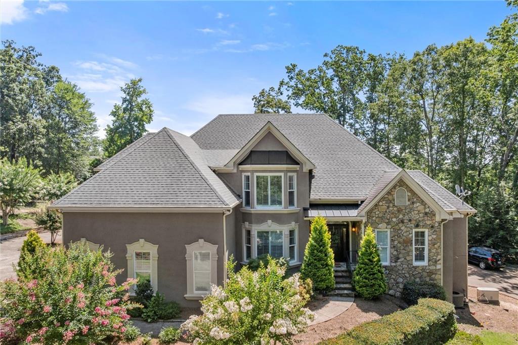 Welcome to 3400 Williams Road — a beautifully updated, private 1-acre estate in the heart of East Cobb, perfectly situated in the top-rated Pope High School district.
This exceptional home combines timeless design with thoughtful modern updates. The exterior features a classic hard-coat stucco and stone façade, complemented by professionally landscaped grounds. Since 2021, the current owner has completed a full renovation of the kitchen, all bathrooms, and laundry room—and even installed new double-paned windows throughout for added efficiency and comfort.
Step into the grand two-story foyer, flowing seamlessly into a dramatic living room filled with natural light—perfect for gatherings or quiet relaxation. The main-level primary suite is a private retreat with tray ceilings and a spa-like bath that includes double vanities, a soaking tub, and a separate walk-in shower. The elegant half bath, designed with Serena & Lily flair, adds a stylish touch for guests.
The expansive eat-in kitchen is both functional and beautiful, with stainless steel appliances, an oversized center island, and generous cabinetry. The adjoining keeping room features a floor-to-ceiling stone fireplace that anchors the space with warmth and charm.
Upstairs are three generously sized bedrooms and two and a half full bathrooms (one with a convenient Jack-and-Jill layout), all with excellent closet space. The fully finished terrace level offers versatility with a private bedroom suite (including a renovated full bath and walk-in closet), a home theater, office, and abundant storage. There is also private garage access on this level with a private second driveway—ideal for guests or multigenerational living.
Step outside to an entertainer’s dream: Brazilian hardwood deck overlooking a beautifully lawn, complete with a newly added hot tub—perfect for both weekend entertaining and quiet evenings under the stars.
One of the most unique features of this home is its six-car garage, ideal for car collectors, boat owners, or anyone in need of secure storage. Additional features include a whole-house generator, newer mechanical systems, and a detached shed currently being used as a dance studio—offering endless possibilities.
This is a rare opportunity to own a truly move-in-ready estate in one of East Cobb’s most desirable areas. Come experience 3400 Williams Road—you won’t be disappointed!