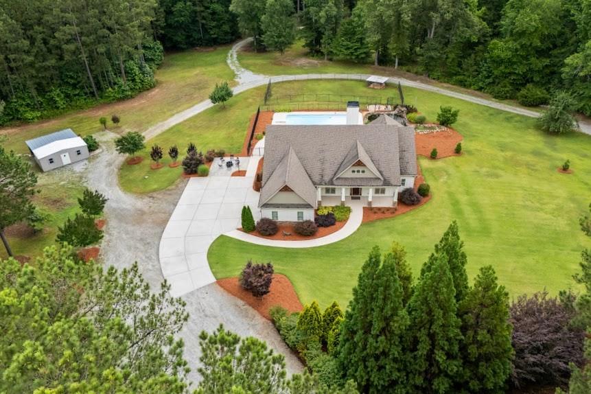 SHOWINGS BY APPOINTMENT ONLY. Private and serene 25+ acre estate in Northern Coweta County with a custom-built 2500 square one-level home. Close to the Serenbe area and easy access to South Fulton Parkway to get to Atlanta. This gated property hosts many incredible features such as the large 3-bay shop (52 x 30), an additional 24 x 40 shed-style barn, a storage building with a shed, spring fed pond with many fish, trails all throughout the property, a creek and hunting sites, wildlife, fruit trees, beautiful established landscaping with irrigation, koi pond and so much more. The home itself was built in 2013 and designed with an open layout, perfect for entertaining and family gatherings. The huge primary bedroom has enough room for an office, nursery space, or sunroom, and hosts a massive en suite bathroom and closet. Additionally, there is a half bath in the hallway and 2 secondary bedrooms with full baths on opposite sides of the home. The laundry room is conveniently located near the garage entrance. Brand new carpet in all the bedrooms, with beautiful hardwoods and tile in the remainder of the home. Built-in surround sound for indoor/outdoor use is perfect for hanging out by the fire pit, swimming in the saltwater pool, or working in the yard. Whether you're an avid hunter, a car enthusiast or just want space and privacy, this property is sure to please.