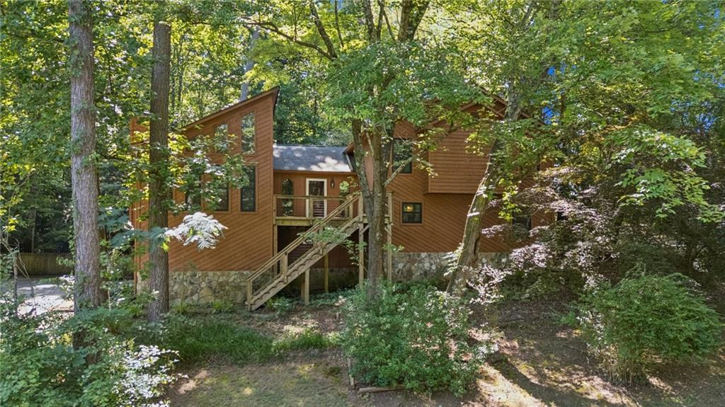 Situated in the beautiful Peachtree Walk community in North Gwinnett County, this split level home makes you fell like you're in a tree house! Welcome inside through the foyer to a Fireside Great Room & Dining Room with updated windows offering views of mature landscaping and plenty of trees. The Kitchen is equipped with upgraded appliances and has access to the private, wooded backyard and massive deck where you can enjoy that morning coffee or evening cocktail. Go downstairs to find an amazing Den with a bar, set up for those family movie nights or the big game. There is also a bedroom, full bath and laundry room on the lower level. Upstairs is the secluded Primary Suite with 2 Walk-in closets, Dual vanities, Whirlpool Soaking tub and separate Shower. Two additional bedrooms share a bathroom upstairs as well. The extra space in the garage provides plenty of storage and a workshop with work bench for all of life's projects. All of this is located in a serene community on over 3/4 acre in North Gwinnett with no HOA! Just minutes from TPC Sugarloaf, Suwanee, John's Creek & I-85.