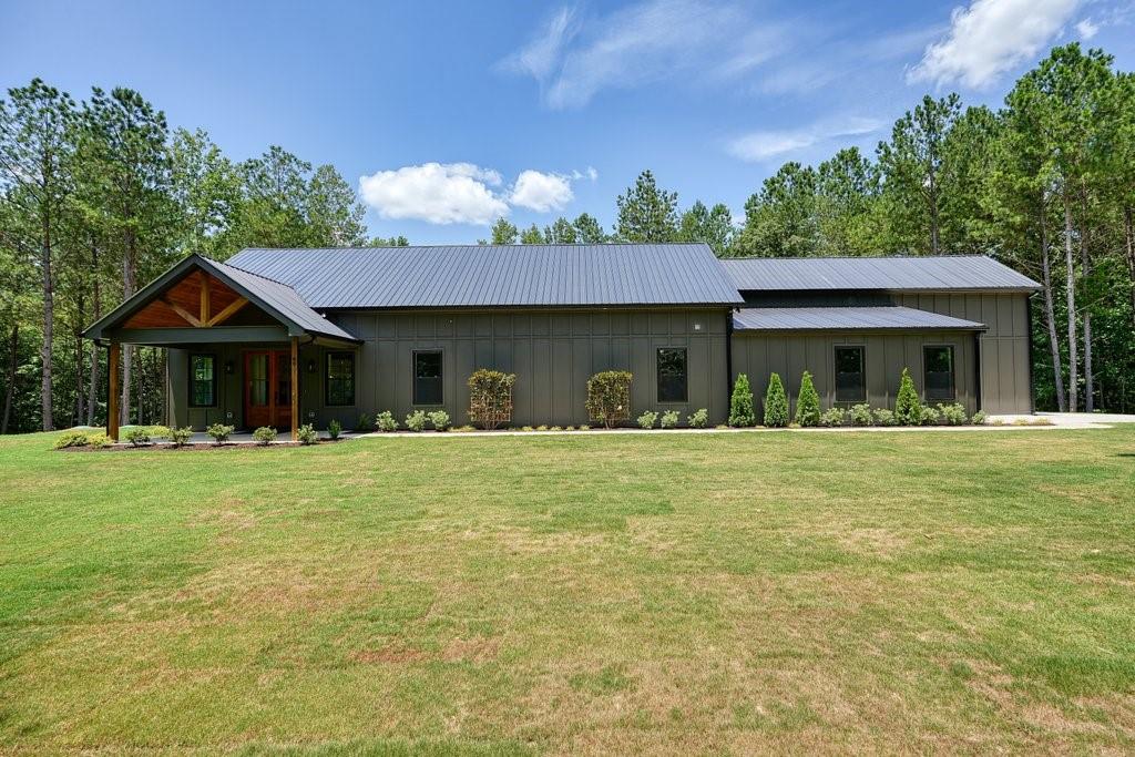 This stunning barndominium sits on 3.71 level acres with no HOA and offers a rare opportunity for a private retreat or future family compound, adjoining four additional lots—two already graded and build-ready, with completed soil reports for all—perfect for future builds, investment potential, or added privacy. (These adjoining lots are available to purchase separately and do not convey with the home.) The single-level home features open-concept living with vaulted ceilings, recessed lighting, and durable laminate flooring, a spacious kitchen with white cabinetry, gorgeous countertops, a large island, and walk-in pantry, plus a custom oversized stained front door that adds natural light and character. The expansive primary suite boasts a spa-like bath with a massive tiled walk-in shower with wall-to-wall bench and double vanity. A main-level laundry includes a utility sink and generous counter space. The oversized attached garage accommodates an RV or motorhome with a 12x16 door, 37-foot depth, and prewired RV plug, while a separate side-entry 1-car garage with opener provides flexibility. Outdoor features include a covered front porch, two detached sheds, landscaped yard, public water, a dug well (pump required), and a backup generator with a 250-gallon propane tank (not currently hooked up).
