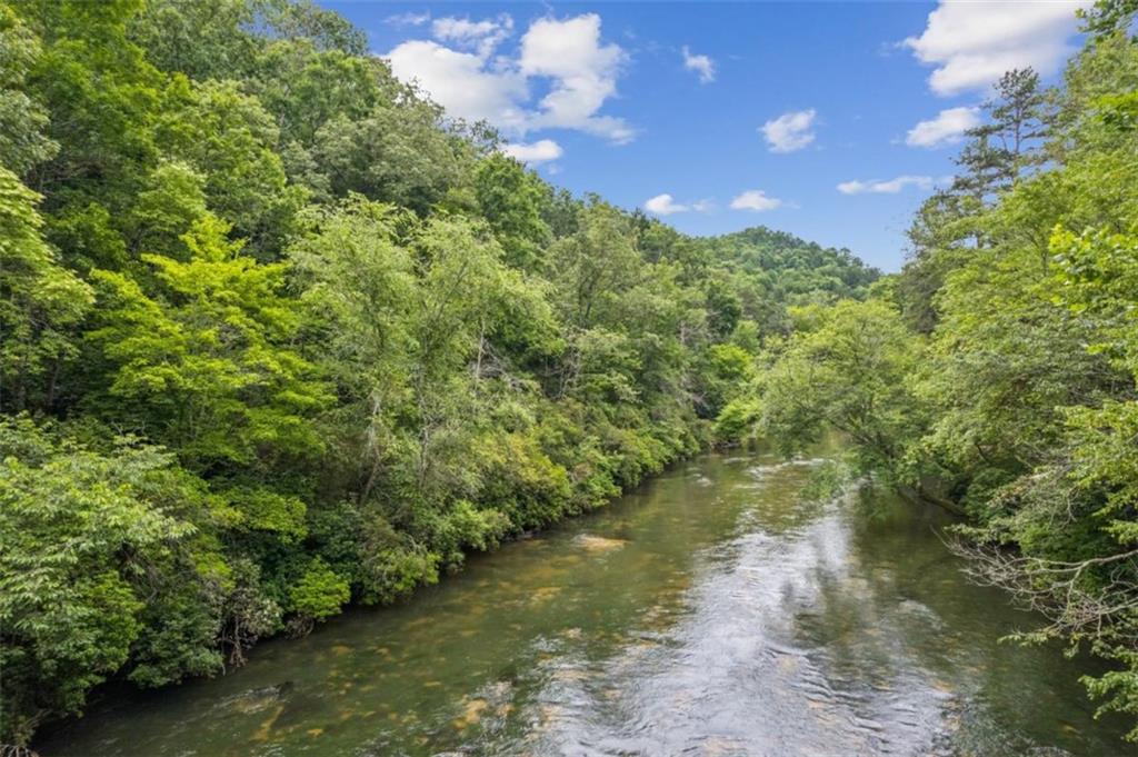Exceptional RIVERFRONT Lot! Discover the opportunity to own 171 feet of river frontage in one of North Georgia's most scenic locations. Enjoy direct access to the Cartecay River, with property lines extending to the river's center—perfect for fishing, kayaking, or simply relaxing to the tranquil sounds of flowing water. A natural slope makes it ideal for a basement-style home. Benefit from the freedom of no HOA fees and no rental restrictions, along with modern conveniences including city water, high-speed internet, and paved access already in place. Just minutes from the refined charm of Downtown Ellijay, this exclusive homesite offers the perfect blend of luxury, nature, and convenience. Adjoining lots #3 (.88 acre), #4 (.66 acre), and #5 (.74 acre) are available for added privacy or expanded estate potential.