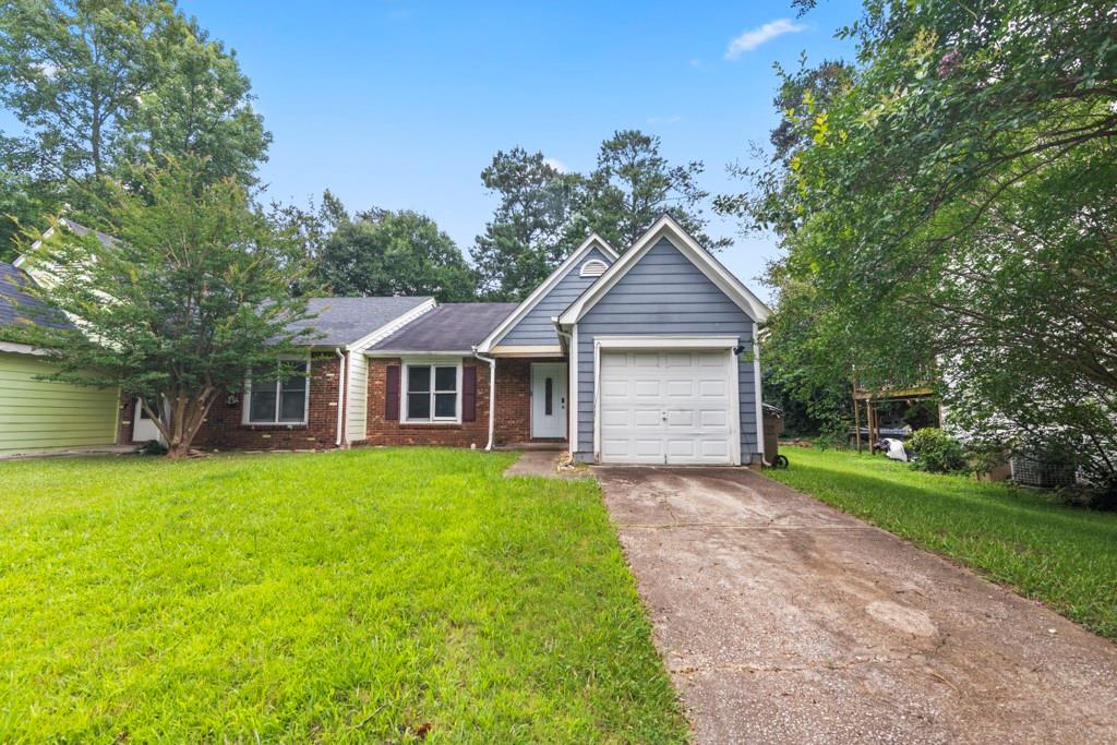 Front exterior featuring a combination of brick and siding, a single-car garage, and a concrete driveway