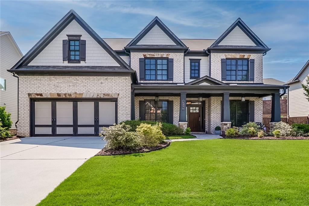 Incredible LIKE NEW CONSTRUCTION home in Suwanee Georgia that's calling your name! This immaculate home has everything you could want. As soon as you pull up you are greeted by a landscaped front yard with front porch and that craftsman like charm. Inside a large foyer greets you with views into the living room and formal dining room. Entire first floor has wide length and light wood floors. The craftsmanship alone is something to marvel at. Fireside family room has a stone fireplace and centers the room. Coffered ceilings, bookshelves, natural light are a few of the highlights. Kitchen overlooks the family room and has white cabinets, granite counters, large kitchen island, eat in breakfast room and updated stainless steel appliances. Oversized primary suite includes tray ceilings, sitting area, and like new carpet. Primary suite bathroom has gorgeous tile floors, double vanities, glass shower and a closet that will make your jaw drip to the floor. Custom cabinets, carpet flooring, natural light are a few of the highlights. Three more well sized bedrooms make up the second floor and each have tall ceilings, closets and a shared bath. Backyard is fully fenced, flat grassy and has a covered patio with stone fireplace for year around enjoyment. Three car tandem car garage is HUGE with tons of storage space, enough to fit a trailer. Neighborhood has sidewalks, swim, tennis and a playground. Located in North Gwinnett High School district. Around the corner from George Pierce Park, Suwanee Town Center and a few miles from Coolray Field, Mall of Georgia, shopping, restaurants and grocery stores.