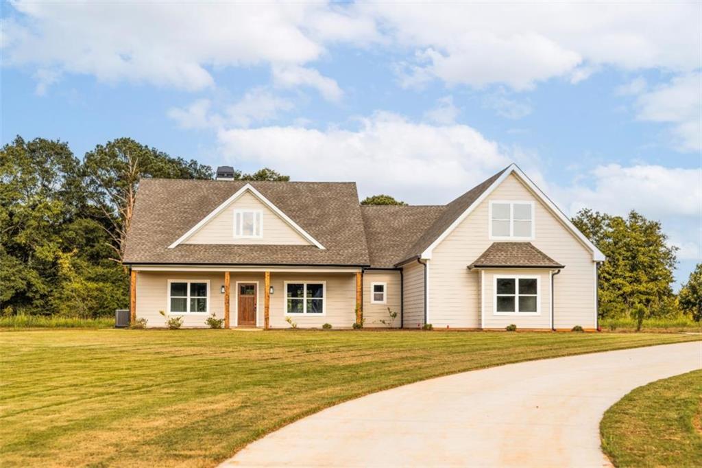 Welcome to 269 Highway 11 in charming Social Circle, Georgia-an exceptional new construction Craftsman-style home nestled on 5 serene acres. This thoughtfully designed 4-bedroom, 3.5-bath residence blends timeless appeal with modern comforts. From the moment you step inside, you're greeted by a grand vaulted living room anchored by a beautiful brick fireplace, creating a warm and inviting space that overlooks the peaceful backyard. The open-concept layout flows seamlessly into the gourmet kitchen, which boasts quartz countertops, stainless steel appliances, a walk-in pantry, and a large island ideal for entertaining or family meals. Just off the kitchen is a spacious dining area perfect for both casual and formal gatherings. The main-level primary suite is a true retreat, featuring abundant natural light, a luxurious bathroom with dual quartz vanities, a freestanding soaking tub, a tile-enclosed shower, and a generous walk-in closet. Two additional bedrooms and a full bath are also located on the main floor, while a private upstairs suite with its own full bath offers the perfect space for guests, a home office, or a flex room. Throughout the home, you'll find upscale touches like durable Revwood flooring, spray-foam insulation for energy efficiency, and detailed finishes including a tongue-and-groove ceiling on the covered rear porch. Outside, the expansive level lot offers endless possibilities for gardening, recreation, or simply enjoying the peaceful surroundings. The covered porch is an ideal spot to start your morning or wind down at sunset. With a two-car garage, electric heating and cooling, a sprinkler system, and no HOA, this home delivers both comfort and freedom. Located in the sought-after Social Circle school district and just a short drive from historic downtown, 269 Highway 11 offers the perfect balance of privacy and convenience in a truly picturesque setting.