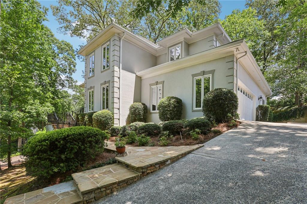 Gorgeous, Move-In Ready Home with Treehouse Charm and Private Backyard Oasis! Welcome to this stunning, move-in ready home nestled among mature trees, offering a tranquil treehouse feel. A charming stone patio sets the stage as you arrive, inviting you into a beautifully maintained residence filled with character and light. Step inside to find gleaming hardwood floors throughout the main level and a dramatic two-story foyer. To the right, a formal living room welcomes guests, while the formal dining room features elegant transom windows and classic chair railing—perfect for hosting. The heart of the home is the impressive living room showcasing soaring ceilings with wood beams and a double-sided fireplace shared with the bright and airy keeping room. Oversized picture windows frame picturesque views of the lush backyard. The modern kitchen is a chef’s dream, complete with granite countertops and backsplash, a large island with a second sink and gas cooktop, stainless steel appliances, double ovens, and two dishwashers. A sunny breakfast room with built-in desk, spacious pantry, and nearby laundry room add to the convenience. Retreat to the main-level primary suite featuring an oversized bedroom with tray ceiling and a cozy sitting area. The en-suite bath offers dual sinks, a soaking tub, and a frameless glass shower. A second full bath leads to a massive walk-in closet that could easily double as an additional bedroom or flex space. Upstairs, you’ll find three spacious bedrooms—all with hardwood floors and NO carpet. One bedroom has its own private en-suite bath, while another has en-suite access to the hall bath. Need more space? Head down to the finished terrace level, offering a large open living area—perfect for a game room, media room, home office, or gym. Two additional flex rooms provide endless possibilities, along with a bedroom, full bath, and extra unfinished space for storage. Outside, the backyard is a peaceful escape with a large stone patio, tranquil raised pond, and a pergola ideal for entertaining or relaxing mornings. Surrounded by mature trees, the garden space, fire pit area, and winding paths create a true secret garden atmosphere. Whether you're looking for the ultimate entertaining home or a serene personal retreat, this exceptional property truly has it all!