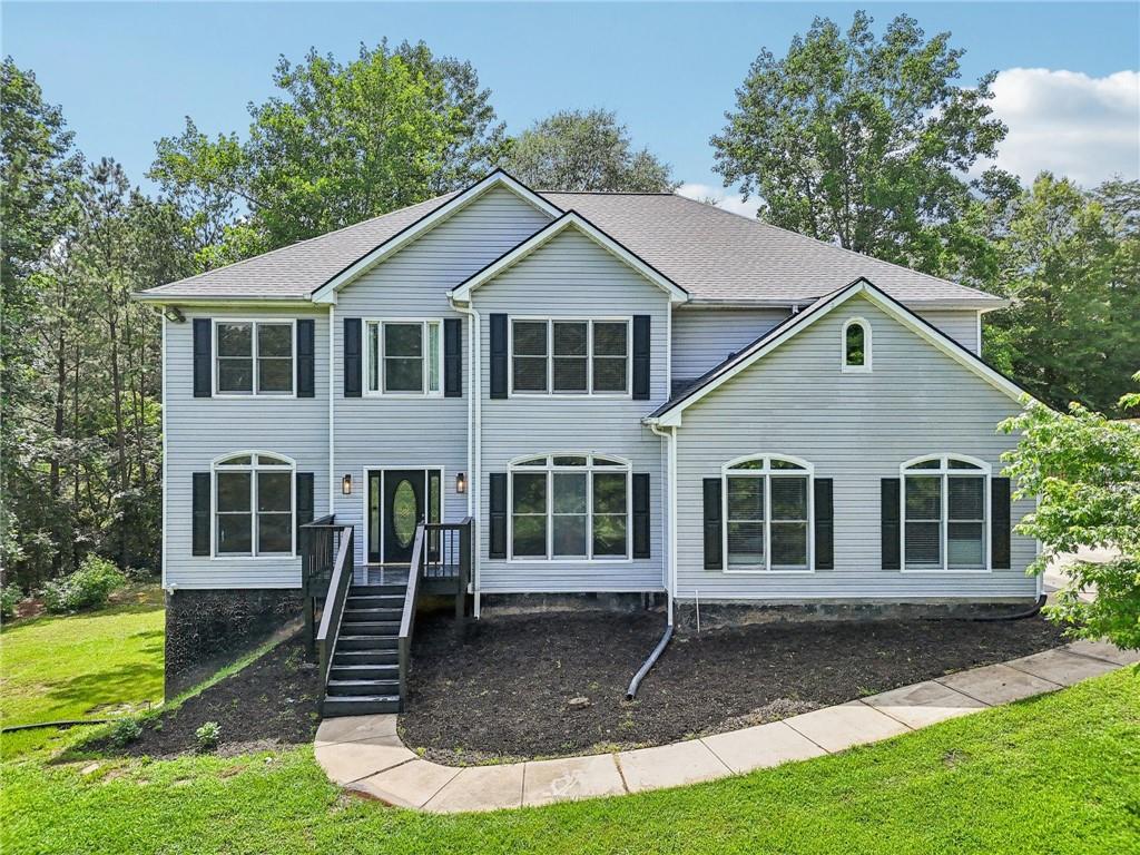 Breathtaking countryside estate nestled on 5.54 private, wooded acres in the heart of Hoschton, GA, within the desirable Mill Creek school cluster. Zoned RA, the property features a half-acre pond, saltwater pool with hot tub, and expansive decks for outdoor living.This 4BR/4.5BA home offers a bright two-story great room with fireplace, formal dining, flexible living/office space, and an updated chef’s kitchen with keeping room, island, stone countertops, double ovens, and walk-in pantry. The oversized owner’s suite includes a sitting area, spa-style bath, and walk-in closet. Three additional bedrooms and two baths are upstairs. A partially finished basement provides recreation space, full bath, storage, and a third garage with separate entry—ideal for a workshop or hobby area. Enjoy peaceful, refined country living just minutes from local amenities.