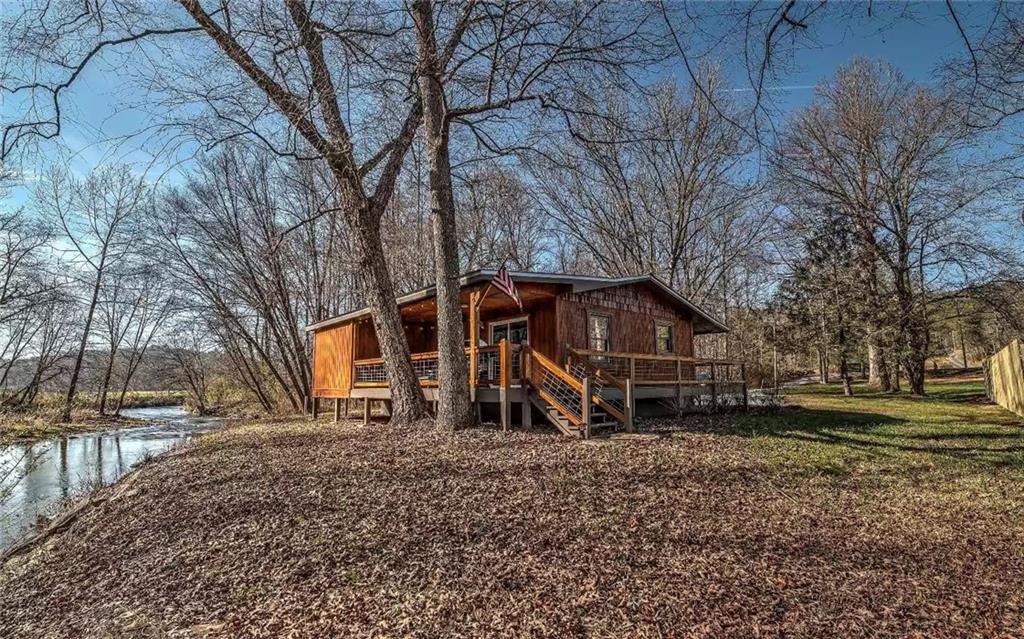 **Charming CREEKSIDE Cabin Retreat on Hemptown Creek** FULLY FURNISHED! EXCELLENT RENTAL HISTORY! Only 10 minutes to downtown Blue Ridge and Lake Blue Ridge. This recently renovated 2-bedroom, 2-bathroom cabin combines modern comforts with rustic charm, making it the perfect retreat for relaxation and adventure. Two Cozy Bedrooms-Each bedroom is designed for comfort, ensuring a restful night's sleep after a day of exploring the great outdoors. Enjoy the convenience and style of updated bathrooms, providing all the amenities you need. Unwind in the private hot tub, where you can soak your cares away while enjoying the tranquil sounds and views of Hemptown Creek. Gather around the fire pit in the evenings for s'mores, stories, and stargazing. Experience the perfect blend of rustic charm and modern convenience with our recent renovations, including updated kitchen appliances, cozy furnishings, and stylish decor. -Step outside and immerse yourself in the beauty of nature with direct access to Hemptown Creek, perfect for fishing, tubing, or simply relaxing by the water. The spacious deck and outdoor seating area provide an ideal space for dining al fresco, grilling, or simply enjoying the serene surroundings. This charming creekside cabin is the epitome of SIRENE.