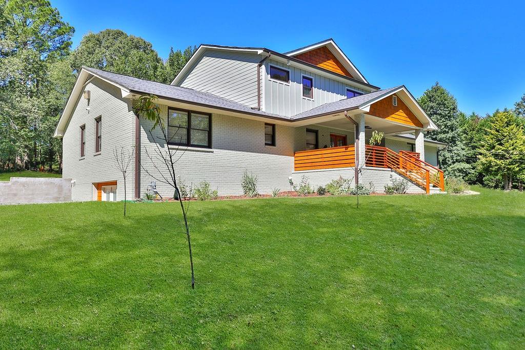 Prepare to fall in love with this stunning 5-bedroom, 4-bath modern farmhouse retreat in the heart of Conyers! Fully renovated in 2022 with all-new systems and contemporary finishes, this home effortlessly blends timeless charm with modern sophistication—all set on 8.64 acres of private, scenic land with trails, RV/boat parking, and plenty of room to roam. From the moment you arrive, the inviting covered porch, lush landscaping, and fruit trees welcome you home. Step through elegant French doors into a bright, open floor plan filled with natural light, gleaming Polyflor hardwoods, and custom details including wainscoting, crown molding, and graceful archways. The chef’s kitchen is the true heart of the home, featuring quartz countertops, subway tile backsplash, stainless steel appliances (including a gas stove with vent hood), a farm sink, breakfast bar, and cozy breakfast area—all with views of the covered sundeck and private wooded backyard. This home is uniquely designed with three oversized primary suites, each with walk-in closets and beautifully appointed en-suite bathrooms. The main-level suites boast features like a bay window sitting area, double vanities, and tiled finishes, while the upstairs suite offers a spa-inspired bath with dual vanities, LED mirrors, and a sleek wet-room tub/shower. Secondary bedrooms are spacious and versatile, perfect for family, guests, or home offices. Additional highlights include: *A sunroom with wrap-around bench seating (ideal as a flex room or lounge) *A full daylight basement, already framed for a kitchen and two bedrooms * Covered porch and sundeck for outdoor entertaining * Designated RV and boat parking with a new asphalt driveway * Wired surveillance system for peace of mind. * Every inch of this home is 3 years new—from plumbing and electrical to the septic system and second-story addition. The only original feature is the timeless 4-sided brick exterior. Whether you’re gathering around the custom fireplace, exploring your private trails on an ATV, or simply enjoying the serenity of nature, this property is a true escape with easy access to Downtown Atlanta in just 30–45 minutes. Welcome Home—where modern luxury meets farmhouse charm on a breathtaking private estate!