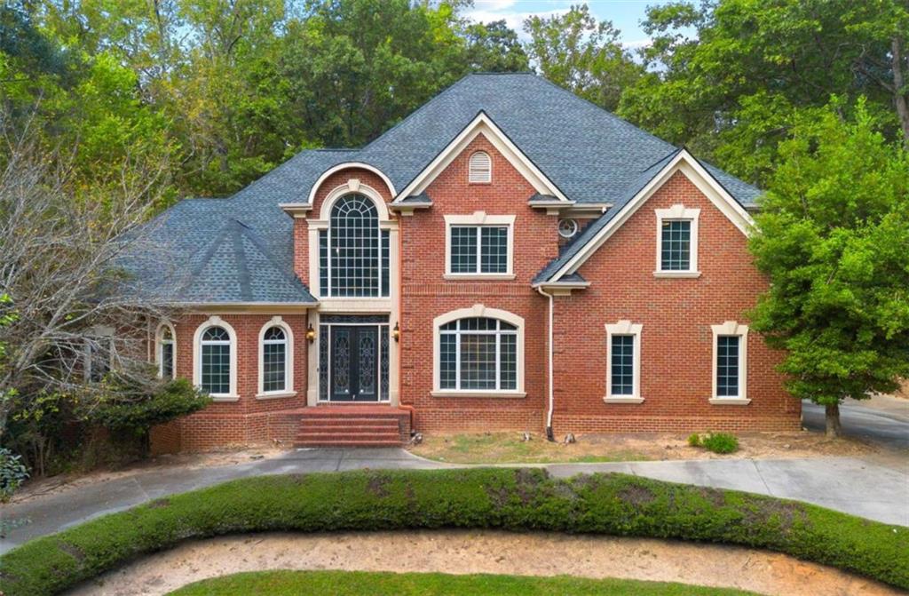 Experience timeless sophistication at 1670 Riverside Road, an extraordinary 9,251 sq ft private estate in the coveted, tree-lined enclave of Roswell, Georgia. Set behind a sweeping driveway and framed by picturesque views, this architectural masterpiece welcomes you with a grand foyer and dramatic curved staircase, unfolding into sun-drenched living spaces with floor-to-ceiling windows and bespoke cabinetry throughout. The owner's suite on the main level is a sanctuary of indulgence, showcasing a spa-inspired bath, oversized boutique closet, and discreet main-level laundry. Curated for exceptional entertaining, the home features keeping and breakfast rooms, a butler's pantry, and a chef's scullery. A fully finished lower level reveals a world-class theater, sauna, full kitchen, and elegant living lounge-perfect for hosting or private retreats. Outdoors, an airy resort-style oasis awaits, anchored by a shimmering pool and generous terraces ideal for alfresco gatherings. A three-car garage completes the estate, which is powered by gas and electric utilities and enriched by an executive study for distinguished work-from-home living. With no HOA and moments from premier country and swim/tennis clubs-The River Club, Roswell Country Club, and Horseshoe Bend Country Club-this residence blends unparalleled privacy with effortless access to the best of North Fulton. Offered at fair market value, 1670 Riverside Road is a statement of artistry, comfort, and enduring luxury.