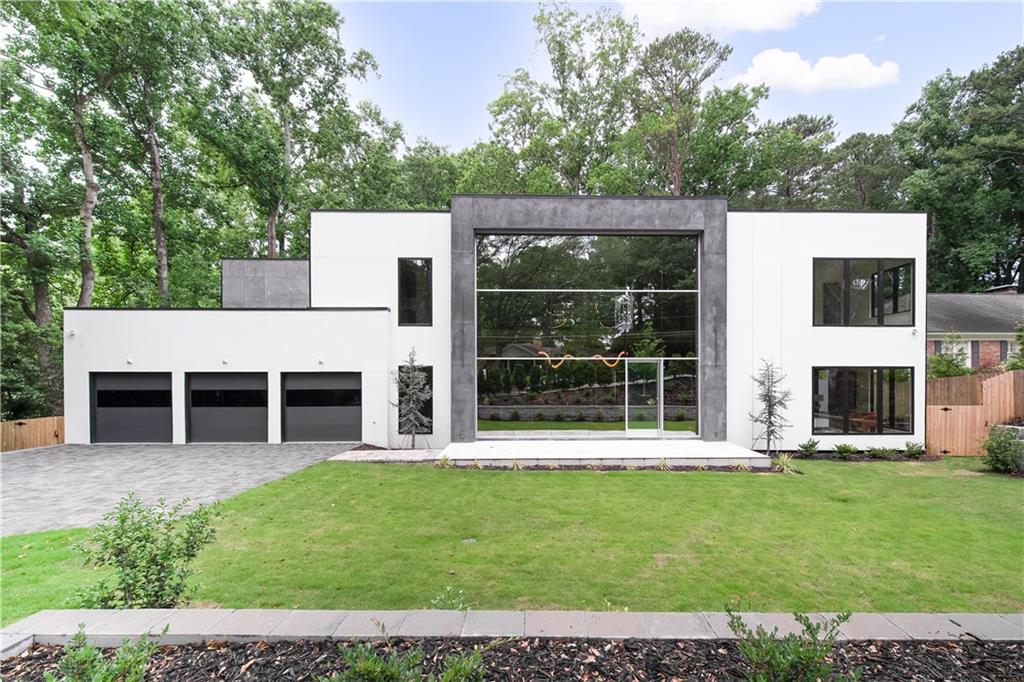 This stunning ultra-modern new construction masterpiece now complete and move-in ready in Chastain Park. Step into a breathtaking two-story entrance featuring handcrafted floating staircases, and warm, sultry textures of Venetian plaster and designer wallpapers. An awe-inspiring custom commercial window wall allows sunlight to pour into the incredible entry way with an immediate view to the pool beyond. The chef's kitchen is a culinary haven, equipped with Wolf and Subzero appliances, including a Wolf gas cooktop and double ovens in the main kitchen. Behind the main kitchen, a full prep kitchen awaits, complete with a second Wolf Range, Subzero Fridge, Dishwasher, sink, and wine fridge, providing the perfect space for a private chef or catering. Sonos invisible speakers are already installed in the living room and controlled via smartphone to set the mood for your day. The ultra-luxurious dining area offers a double- sided glass wine feature wall, perfect for entertaining. Slide open the many multi-slide doors that bring the outdoors in - step out to a stunning patio and heated salt-water pool and spa. The main level boasts a junior primary suite with spacious walk-in closets featuring custom-built cabinets and shelving, ensuring storage needs are met with elegance and practicality. Upstairs, the large primary oasis awaits, featuring oversized his and hers closets with built-in cabinets and shelving. The spa-like primary bath is a sanctuary of relaxation, adorned with curved glass doors and covered in stunning porcelain slabs. This home is designed for modern living, with every convenience at your fingertips. It is fully integrated into a SmartHome system, offering Lutron automation throughout. The 3-car garage is wired for EV charging stations in all three bays, catering to electric vehicle enthusiasts. In the basement, a spacious rec room awaits, fully wired for a 7.1 home theater system, providing endless entertainment possibilities. Don't miss the opportunity to make this exceptional residence your own, where modern luxury and thoughtful design converge to create an unparalleled living experience. Just steps from Chastain Park itself, this home offers a private and secluded feel, while offering the luxurious conveniences of Buckhead just minutes away.