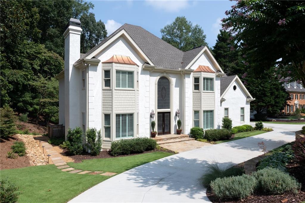 Welcome to a truly one-of-a-kind luxury home in the Sandy Springs Panhandle. Nestled on a beautifully landscaped .6-acre private cul-de-sac corner lot, this meticulous maintained 6,396 square foot hardcoat stucco home seamlessly blends elegance and functionality. Offering three finished levels and a complete remodel valued at over $500,000, it is a residence designed for both style and comfort. From the moment you arrive, the circular drive, manicured lawn, and mahogany double doors with custom leaded glass create a striking first impression.
Step inside to a soaring 18-foot foyer highlighted by a crystal chandelier. The interior features hardwood flooring on all three levels, solid-core doors with Baldwin Estate hardware, LED recessed lighting, and custom plantation shutters.
The chef’s kitchen is a dream, showcasing stainless-steel Thermador 5-burner gas cooktop and double oven and Sub-Zero appliances, porcelain counters and backsplash, and custom cabinetry. A breakfast area overlooks the expansive new 16’ x 44’ deck and private backyard retreat. Multiple living spaces include both formal and casual rooms, a formal dining room with a crystal chandelier, two fireplaces, and a custom bar—perfect for entertaining.
The primary suite is a true oasis, offering a sitting area, coffered ceiling, and a custom dual walk-in closet. The spa-inspired bath features Italian porcelain tile, a soaking tub overlooking the private backyard, a Grohe shower system, dual quartzite custom vanities, Toto Washlet, and LED anti-fog mirrors. The upper level also offers four additional bedrooms, each with an Elfa shelving closet, three remodeled full baths, and a cedar closet for additional storage.
The finished terrace level adds 1,200+ sq. ft. of flexible living space, complete with hardwood floors, a media room, bedroom, full bath, second laundry area, and an arched 2-tiered custom bar with Calico glass backsplash and dual-zone wine chiller. The terrace is wired and plumbed for a home theater and second kitchen, making it an ideal in-law suite.
Outdoor living shines with a spacious walkout paver patio, gorgeous paver fire-pit, professional lighting, and space to add a pool—perfect for day-to-night entertaining. Additional upgrades include Pella windows, whole home audio system, a 25KW generator, spray foam attic insulation, three HVAC systems with electronic filters, Polyaspartic garage flooring, stone retaining walls and much more!
Community amenities feature a swimming pool, lighted tennis and pickleball courts, playgrounds, a lake for fishing, and a vibrant social scene for all ages. Ideally located near GA-400 and I-285, with easy access to the Perimeter, Buckhead, Roswell, Norcross, Peachtree Corners, and top-rated private and public schools, this executive home offers unmatched convenience.
With its luxurious finishes, extensive upgrades, and ideal location, this Sandy Springs residence is truly a one-of-a-kind home.