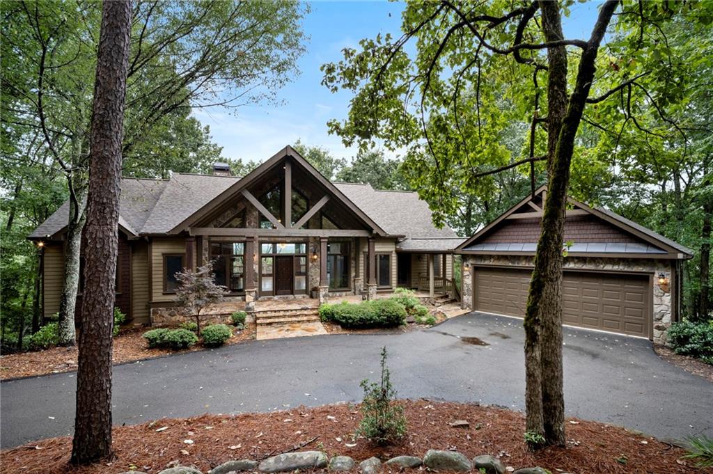 Well appointed 4 BR & 3.5 BATH design Executive home with an expansive open floorplan located on top of Summit with panoramic long range mountain views from every vantage point. Hardwood floors throughout the main level, high volume ceilings with exposed wood beams and stacked stone fireplace from floor to ceiling, built-in cabinets, and the back wall is home to a wall of windows with views from every vantage point. Cathedral ceiling with T&G wood in the kitchen and dining area, plus a keeping room /study with large picture windows on 3 sides of this space to enjoy long range views from as an added bonus. Oversize gourmet kitchen with stainless steel appliances, solid wood cabinets, quartz countertops, work island and breakfast nook area. Oversize Master BR suite with double trey ceiling, hardwood floors and large picture windows, and the expansive master bath is equipped with a steam shower and separate walk-in jacuzzi tub, plus custom built-in shelving in the master closet. On the terrace level there are two additional bedroom enclave suites, a large family room with stacked stone fireplace, large built-in bar with kitchenette ideal for entertaining, and a custom-built wine cellar that cost over $50,000 to complete. In addition, the movie room downstairs was originally the 4th bedroom, but can easily be converted back into additional sleeping quarters if needed. Pella windows throughout, flagstone covered front porch, EZ Breeze enclosed porch and expansive deck area with maintenance free Trex boards on the main and covered deck on the terrace level. A circular driveway for easy access, centrally located within the community with close proximity to the amenities, and located just 5 minutes to the North Gate for quick ingress and egress. This special one of a kind home delivers rustic elegance throughout. A must see!