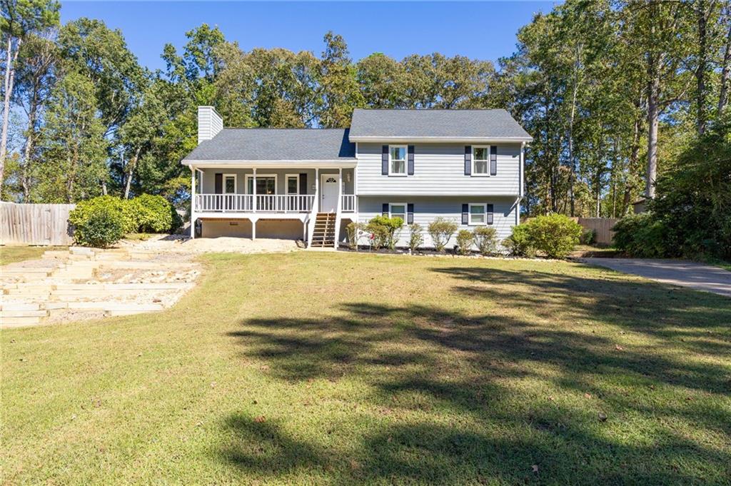 Tucked in the quiet Magnolia Walk community, this Woodstock split-level offers plenty of space inside and out! Set on a spacious, fenced lot with a huge front yard, this home welcomes you with a covered front porch leading into a bright entryway and vaulted fireside family room filled with natural light. The layout flows to a separate dining room and an eat-in kitchen with stained cabinetry and plenty of room for gathering. Upstairs, the primary suite features a walk-in closet and a tub/shower combo, while two secondary bedrooms share a nicely sized hall bath. A convenient laundry room is located in the upstairs hall. The two-car garage includes a storage closet and additional space for tools or equipment. Enjoy outdoor living on the oversized rear deck overlooking the private backyard. Recent updates include a new roof (2020), newer HVAC, new front windows and door, fresh interior paint, tree removal to open up the lot, new rear deck, front stairs, and fencing. Located in the established Magnolia Walk neighborhood with no HOA, this home offers easy access to Lake Allatoona, nearby trails and parks, Hobgood Park, Rope Mill Park, the Outlet Shoppes, and Downtown Woodstock. A wonderful opportunity to call this spacious home your own in one of Woodstock's most convenient locations!