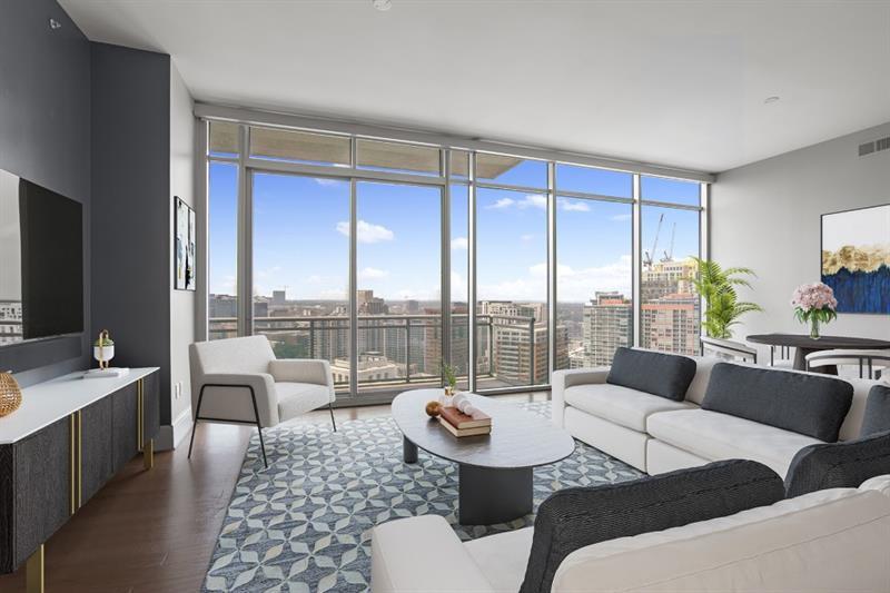 Unbelievable, unobstructed downtown views from EVERY room in this gorgeous condominium home. Wide open living area, plus oversized primary suite, and guest suite. Extensive and expensive upgrades throughout, including electronic shades, automatic black out shades in primary suite, audio visual equipment, smart home features, hardwood floors, kitchen cabinets and appliances, all of which stay with the home along with TVs in each room! Only 52 exclusive homes rest above The Loews Hotel alongside very stringent security, in a midtown location that provides the easiest access to the rest of Midtown and Atlanta. Living above the Loews Hotel in this premier Midtown location provides owner access to over the top gym, spa,  28th floor rooftop pool and club room, way above what you see in other condominium towers. Hotel services are available at your fingertips including a dedicated concierge service. Moments to Piedmont Park and the Atlanta Belt Line in minutes, along with dozens of restaurants and bars! The Loews Hotel is pet friendly and a dog park is conveniently located just a block away.  Parking is very convenient, with two deeded spaces, guests can easily access hotel parking and hotel valet services as well.  An extra level of security is provided by an exclusive owner entry gate into the owner's parking area. A spacious storage area is also located on the same level as parking. Several photos in this listing have been virtually staged.