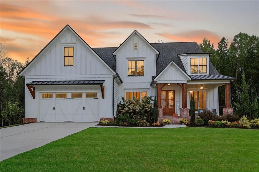 Crafted by esteemed builder Bercher Homes, this residence showcases the highly coveted Evans floor plan — one of West Cobb’s most sought-after designs. Perfectly positioned at the end of a quiet cul-de-sac and framed by untouched natural landscape, the home offers rare privacy, timeless elegance, and an inviting sense of tranquility.

Upon entry, the grandeur of the two-story family room immediately captivates, where 20-foot ceilings rise above a dramatic two-story wood-burning fireplace. A Juliet balcony from the loft overlooks this magnificent space, while 10-foot ceilings on the main level and 9-foot ceilings upstairs enhance the sense of scale and light throughout. At the heart of the home, a chef’s kitchen is equipped with a five-burner gas cooktop and an expansive 10-foot island that flows seamlessly into the family room. Walls of windows frame sweeping views of treetops and the surrounding natural landscape, creating a serene backdrop for everyday living and entertaining.

The main level is anchored by a refined owner’s suite, complete with a custom boutique-style closet measuring 108 inches wide by nearly 18 feet deep — a retreat as functional as it is luxurious. From the suite, step out to a screened porch and oversized deck, where nature becomes a private extension of your living space. The breakfast area offers a daily connection to the outdoors, with views of lush greenery and the glimmer of the lake beyond.

Upstairs, three spacious bedrooms with en-suite access and generous walk-in closets are joined by a versatile loft space overlooking the family room. Below, a 2,500+ square foot unfinished basement presents a rare opportunity to create a bespoke retreat, whether envisioned as a wellness sanctuary, wine cellar, or home theater. Practical modernity is seamlessly woven in with an electric vehicle charging station already installed in the garage.

The lifestyle extends gracefully beyond the home itself. The community offers thoughtful amenities — including a pool, pickleball and tennis courts, clubhouse, and twin lakes for fishing and canoeing — all positioned nearby to preserve the home’s privacy while enhancing an active and social way of life. Two private walking trails begin just beyond the property, connecting you effortlessly to nature.

Located in desirable West Cobb, this home is just seven minutes from vibrant Marietta Square, with its abundance of dining, boutiques, and community events. Historic Kennesaw Mountain offers trails steeped in history and natural beauty, while premier private schools — Mount Paran Christian (7 minutes), The Walker School (16 minutes), and North Cobb Christian (22 minutes) — are within easy reach. Kennestone Hospital is also minutes away, providing peace of mind.

This is more than a home; it is a statement of refined living — where architectural beauty, modern convenience, and natural tranquility converge in perfect balance.