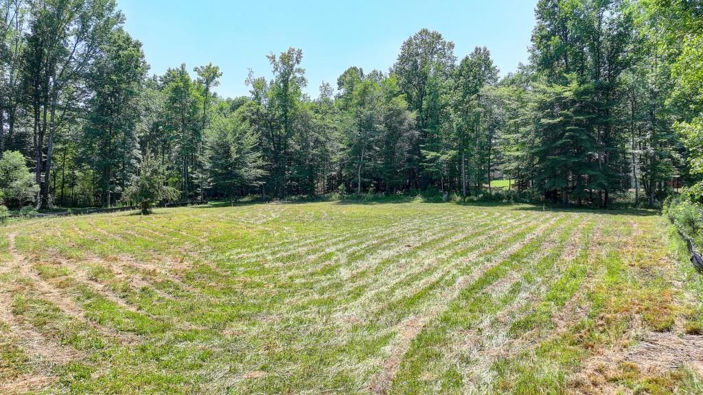 This rare, perfectly flat, 3.1 acre useable lot located in highly desirable Southeast Cherokee County offers an incredible opportunity to create a private retreat, estate, or hobby farm. Build your dream estate home with a coveted main level walkout pool backyard and partially wooded private backyard with room for a pool house. Live the hobby farm lifestyle with a chicken coop, garden, barn, farm animals, and bring all the toys, too! Long, private driveway can be easily enhanced with Leland Cypress or other natural screening for added seclusion. The property opens up into a wide clear expanse of land ideal for a custom build. Zoned for agriculture, with No HOA, the possibilities are truly endless! A successful perc test has been performed, and survey and utilities are available. Surrounded by $2M+ estate homes and equestrian farms. Conveniently located for easy access to Milton, Alpharetta, Cumming, Roswell, Woodstock, Crabapple, Canton, and Hickory Flat, this lot offers the perfect blend of tranquility and convenience. Within 20 minutes of The Avalon and Alpharetta City Center, the Outlet Shoppes in Woodstock and Halcyon, and the Collection in Forsyth. Excellent schools, and favorable Cherokee County taxes. If you are seeking an experienced and professional builder with a proven track record in the area we've got a match for you. Alternatively, bring your own builder and apply for your permit right away. This is the dream lot you have been waiting for!