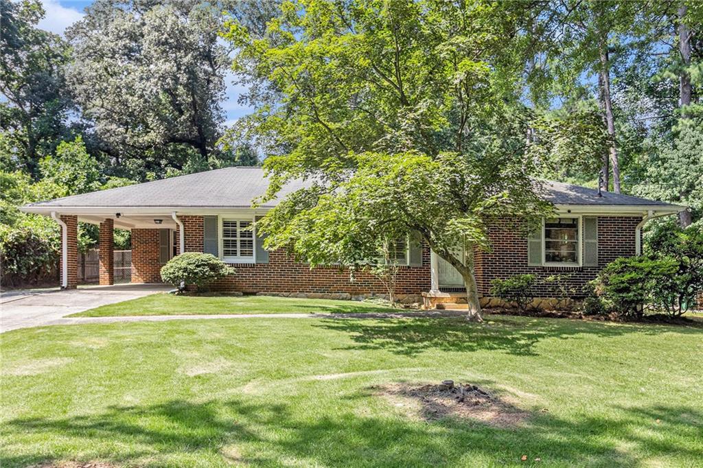 Welcome to your dream home overlooking paradise gardens! This beautifully appointed brick ranch boasts an inviting foyer and an open concept layout that seamlessly blends the kitchen, living room, and dining area. The heart of the home features a spacious kitchen with abundant counter space, stylish cabinetry, and a cork floor that adds warmth and character. Step into the 300 sq ft sunroom (not included in the listed square feet) where 2 sets of patio doors lead you to a stunning flagstone patio—perfect for entertaining or enjoying peaceful evenings. Adjacent to the patio, a covered deck overlooks a flat, private, and beautifully landscaped yard, ideal for gardening, games, or basking in tranquility. Inside, you’ll find exquisite hardwood floors and energy-efficient double-pane windows throughout. Indulge in the spa-like full bath with its luxurious Creekstone shower floor and tile. Other features include: Separate laundry room, built in office, Plantation Shutters, & a 1 car carport* Need another bath someday? No problem...there is a huge hall storage room that could become the master bath (see floor plan). Deep plant and usable lot nestled in a quiet, central neighborhood location 3 blocks from Lindmoor Swim & Tennis. Amazing convenience to Emory, CDC, VA, CHOA, downtown Decatur, & Your Dekalb Farmers Market. Don’t miss the chance to make this captivating property your own!